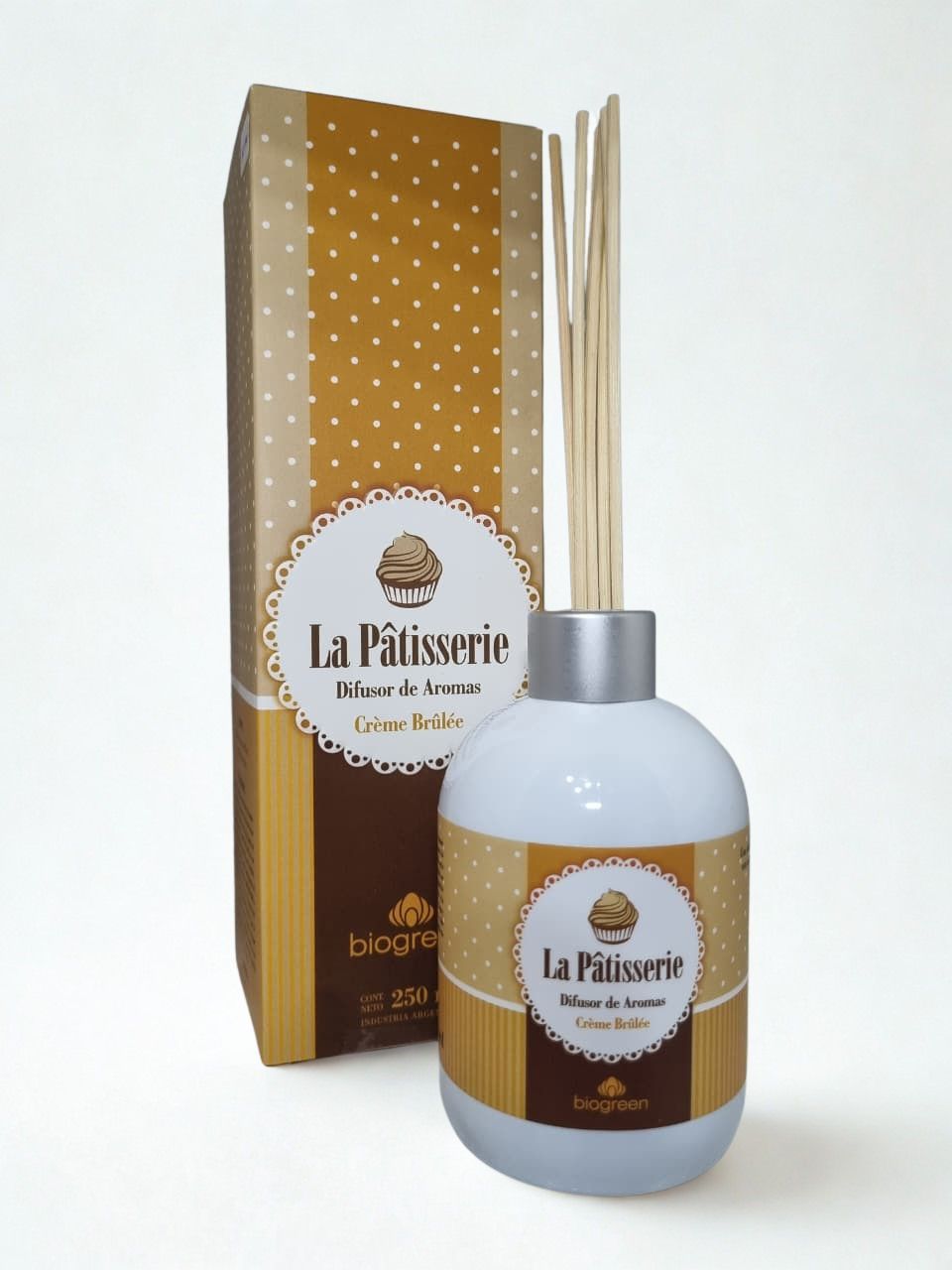 Frasco de loción La Pairsine y caja dorada de lunares sobre fondo blanco.