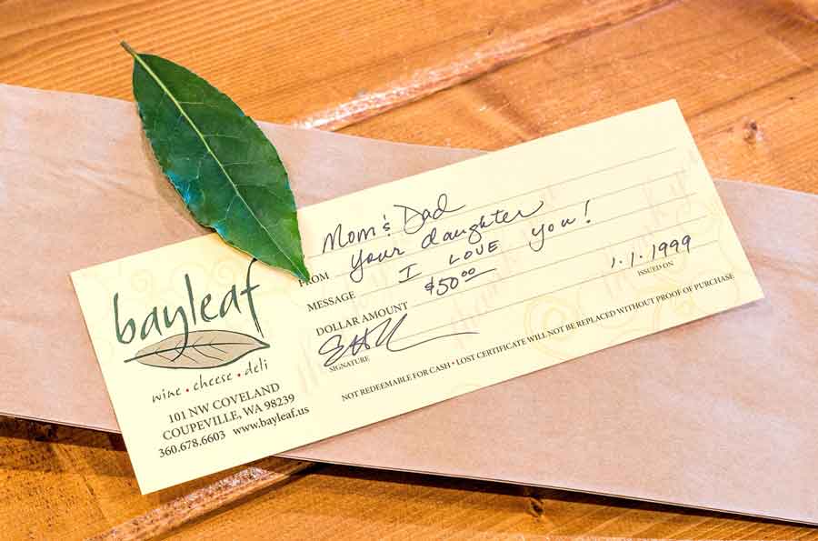 a check is sitting on a wooden table next to a leaf .