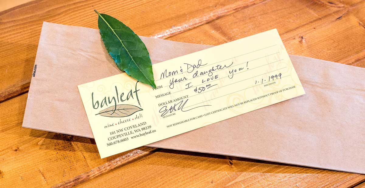 a piece of paper with a leaf on top of it on a wooden table .