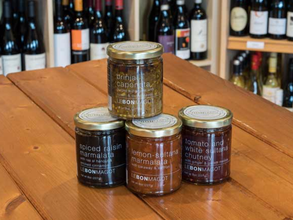 four jars of food are stacked on top of each other on a wooden table .