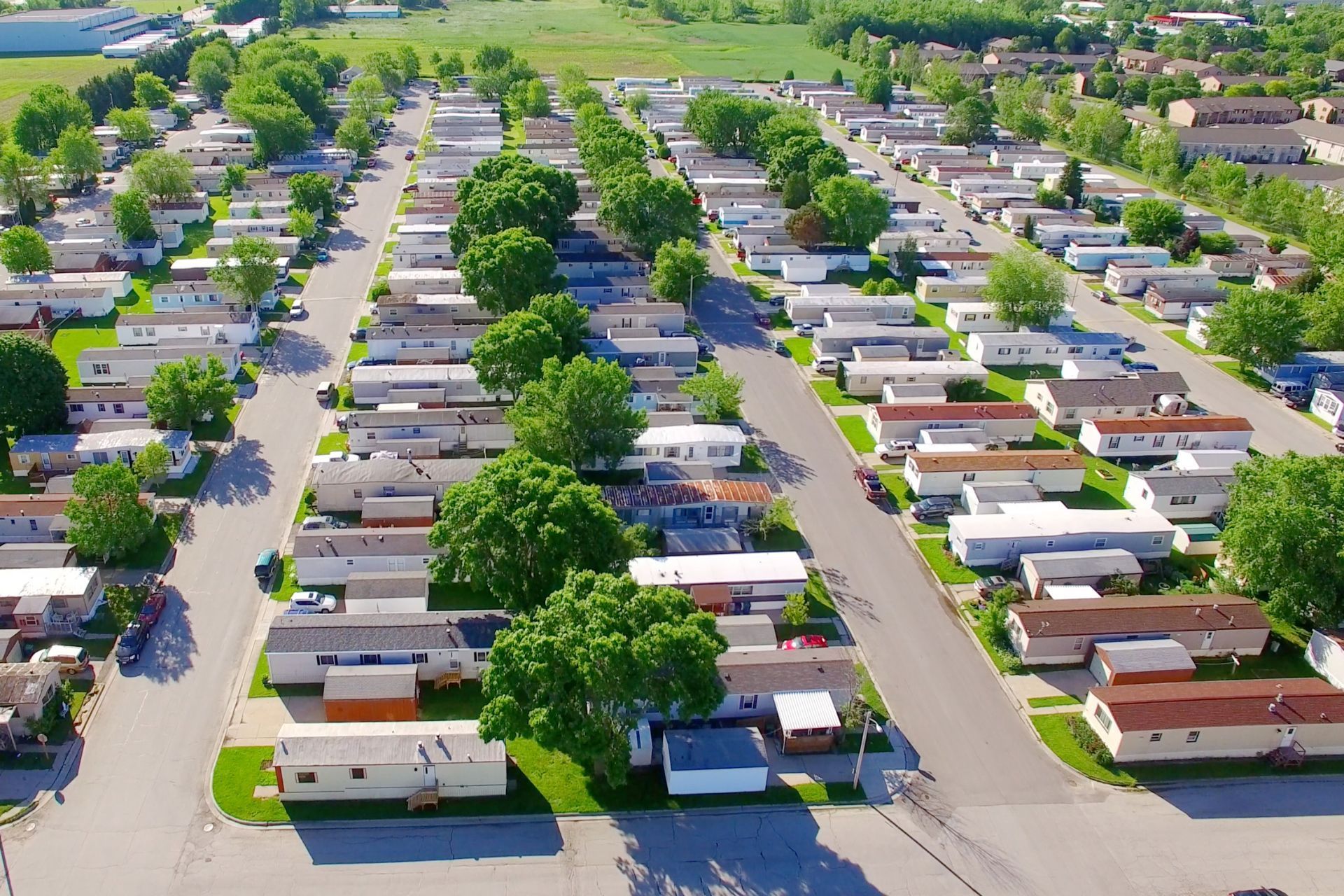 A white rv is parked in a lot with trees