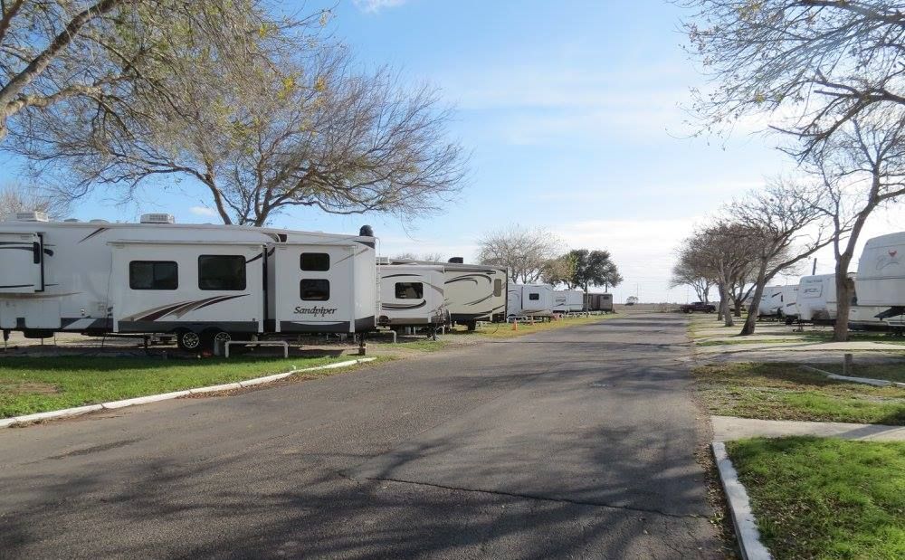 A rv is parked on the side of a dirt road.