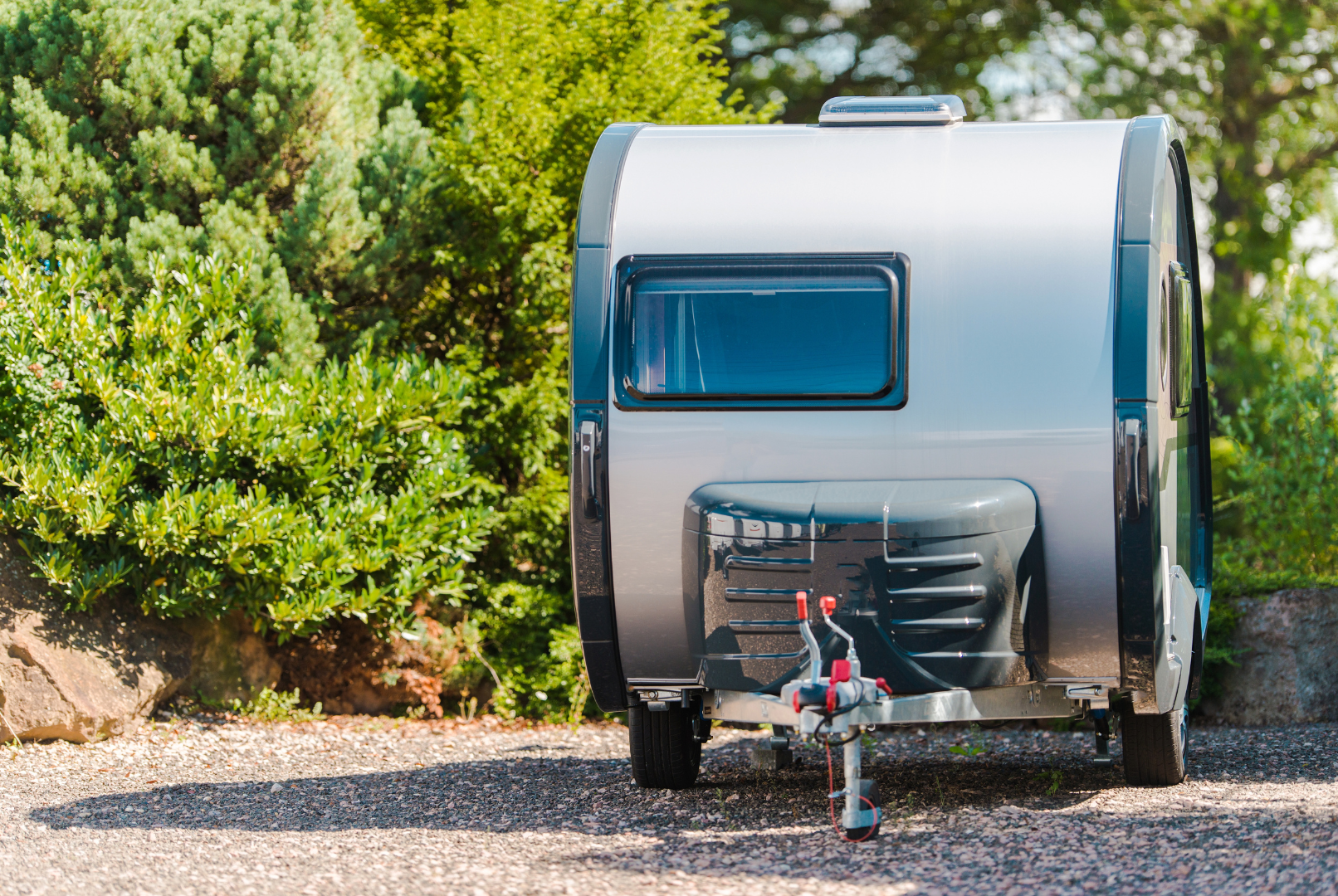 A man and a child are roasting marshmallows over a campfire in front of a rv.
