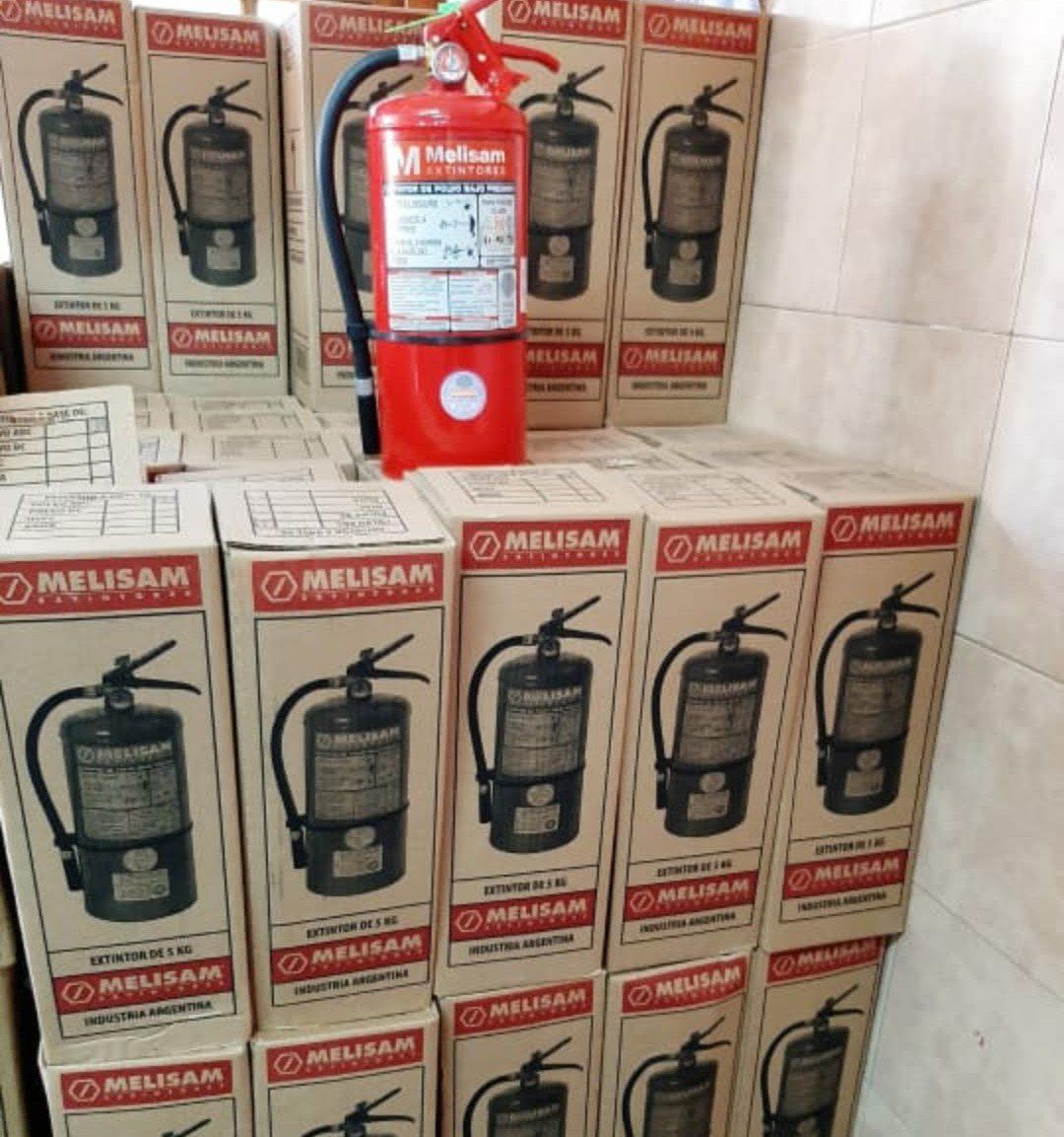 Las cajas de extintores Melissa están apiladas una encima de otra.