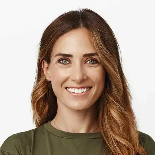 Woman with long, wavy brown hair smiles at the camera, wearing an olive-green shirt.