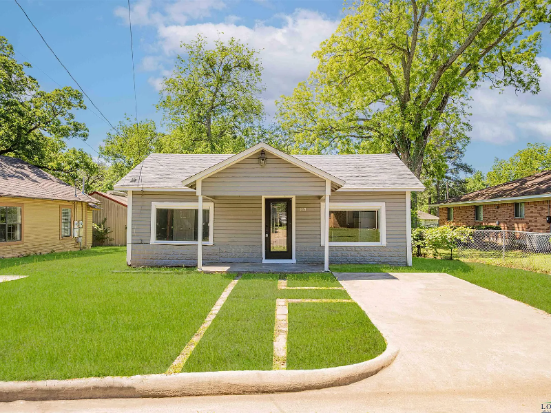 Gray bungalow house with a small lawn and driveway.