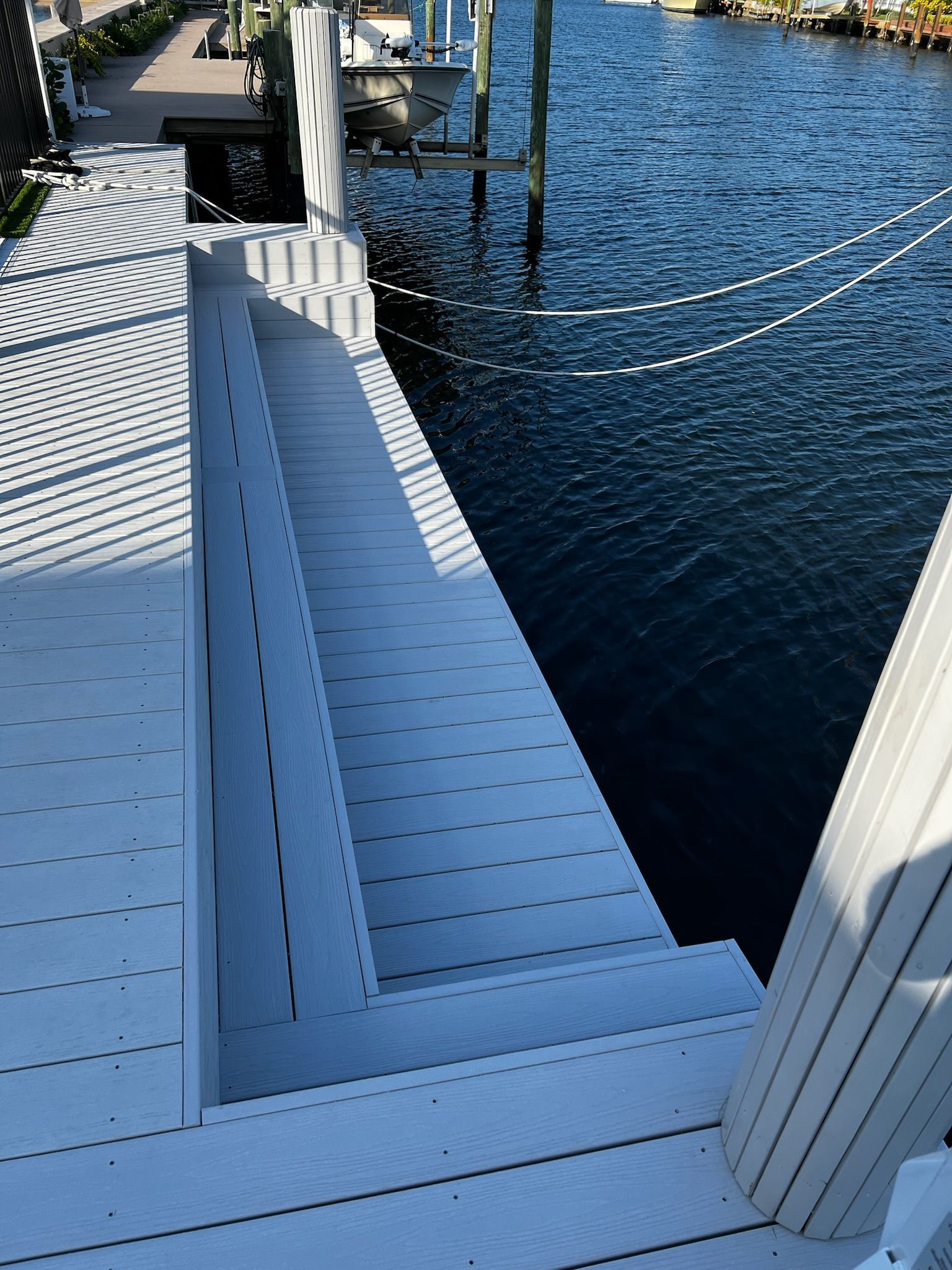 A white staircase leading to a body of water