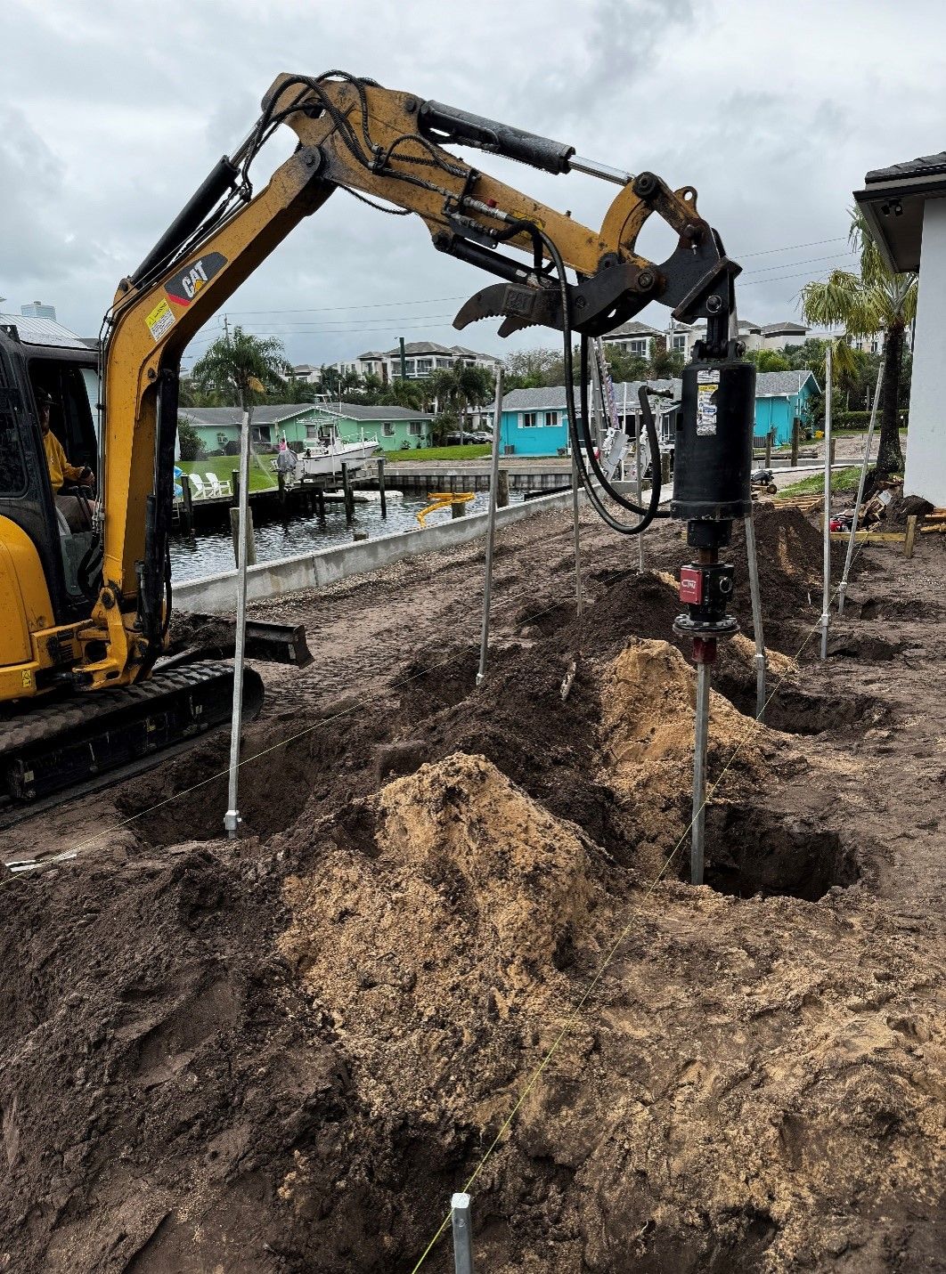 A yellow excavator is digging a hole in the ground.