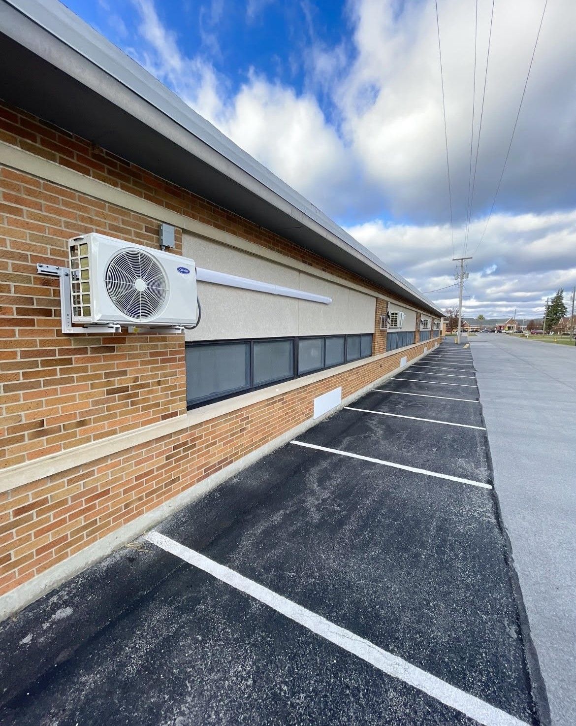 two air conditioners are sitting on the side of a brick house .