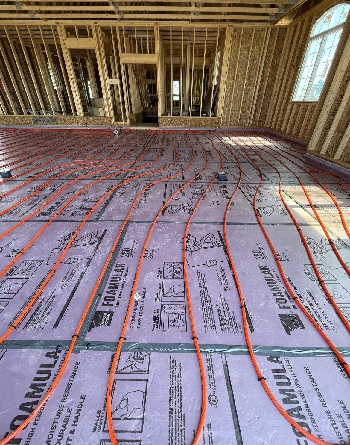 a room in a house under construction with a lot of wires on the floor .