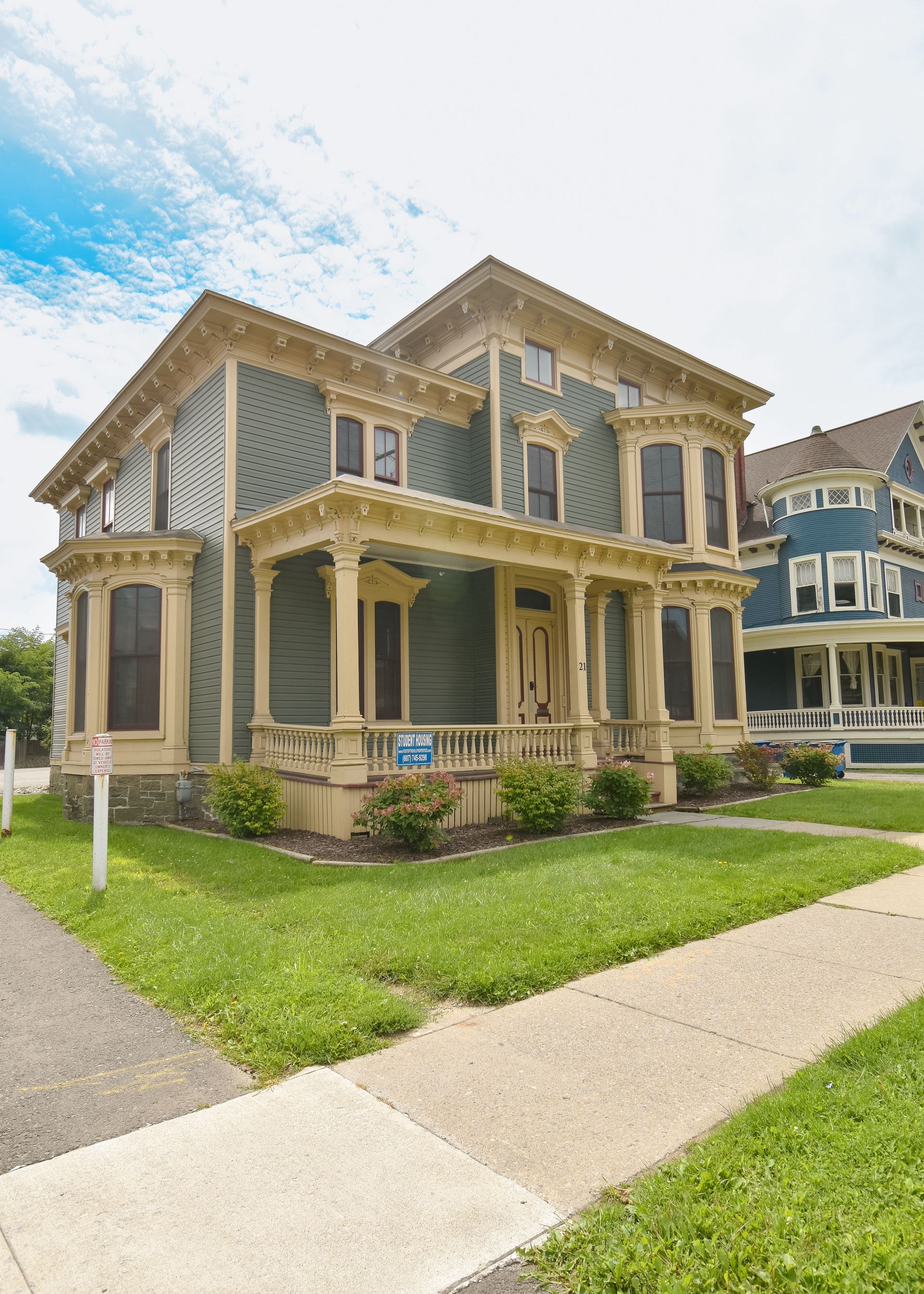 21 Tompkins  – Elegant historic-style blue house with ornate cream trim and a landscaped front yard.