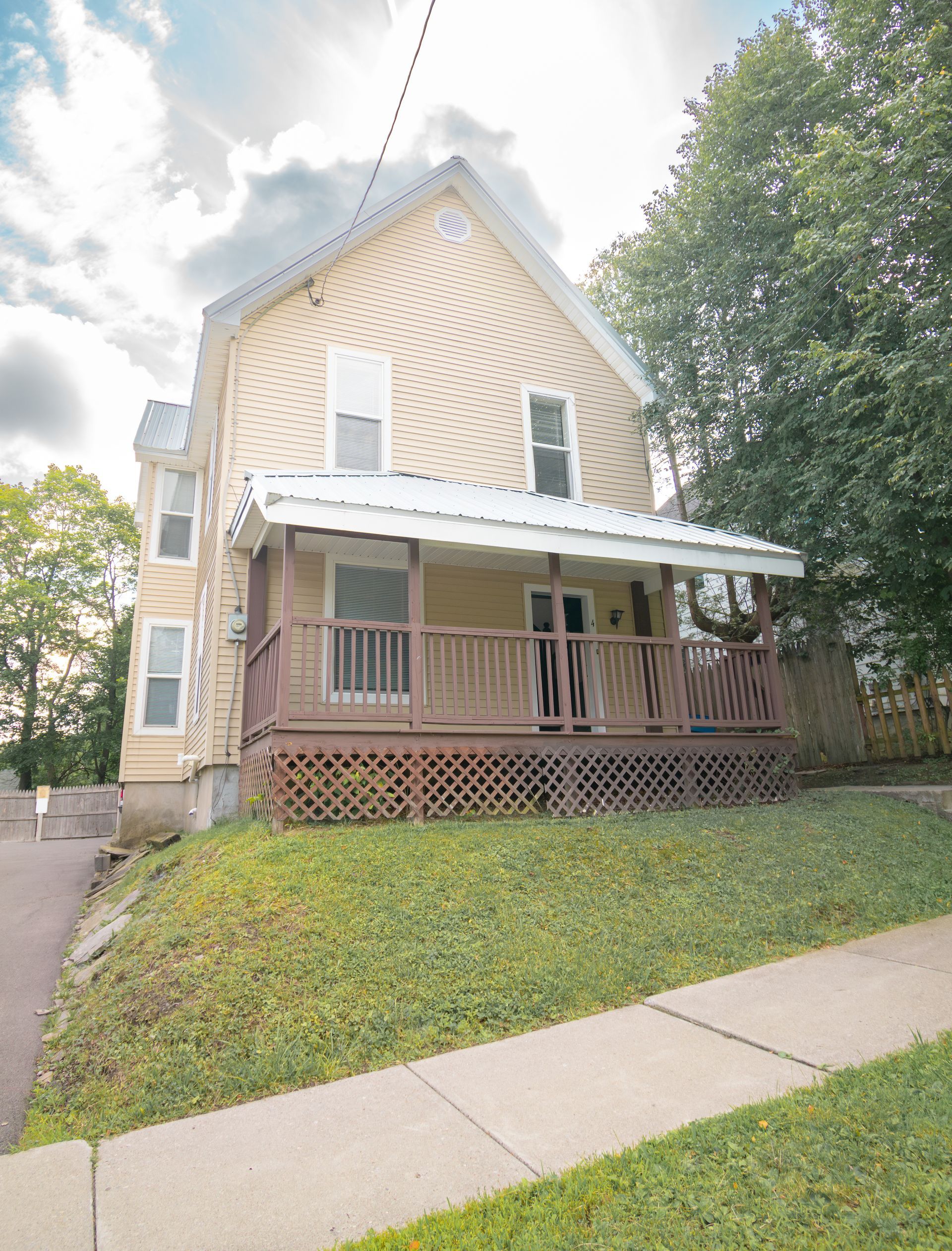 4 Stevenson  – Beige two-story house with a covered wooden front porch and lattice skirting.
