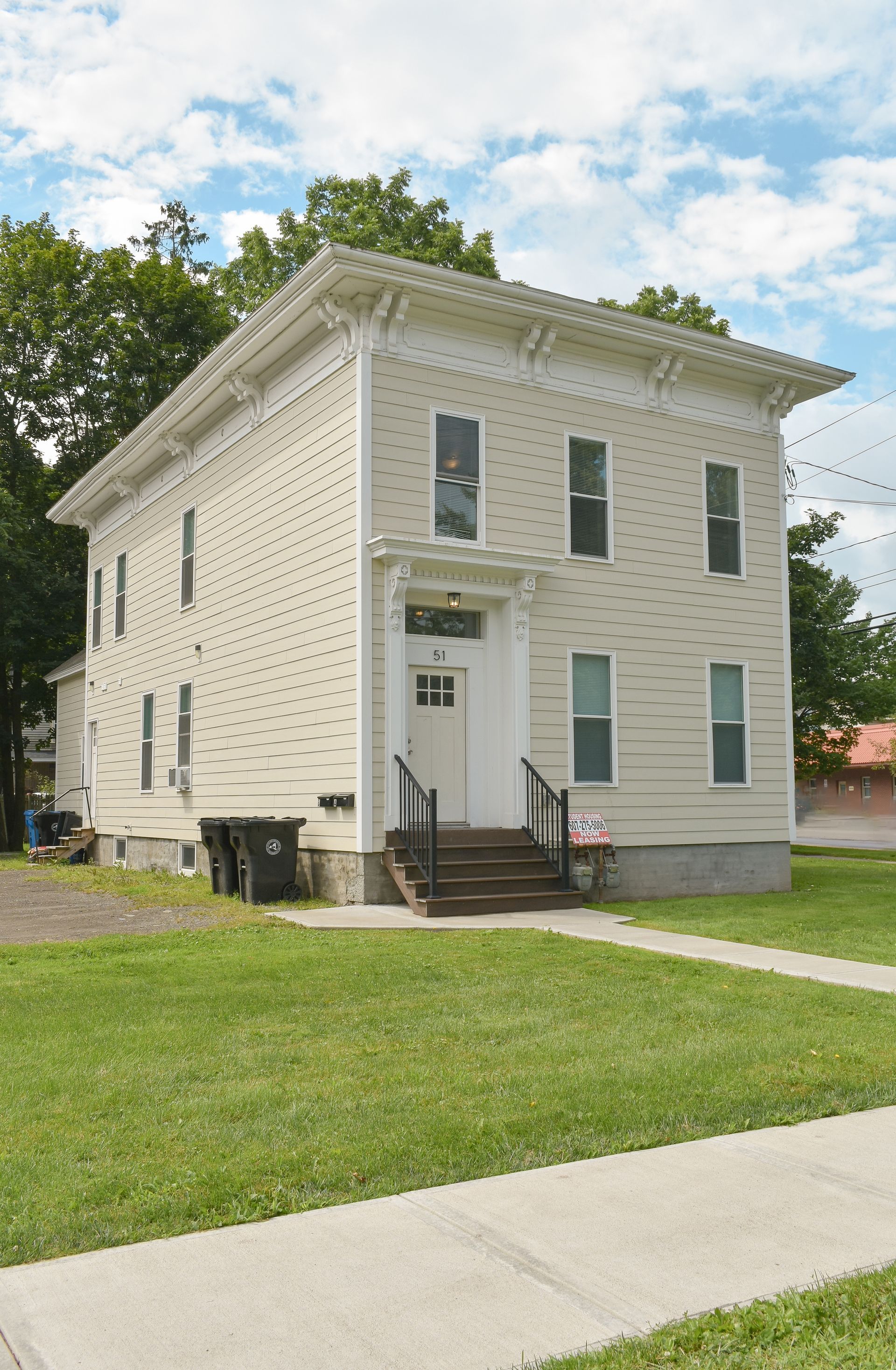 51 Union – Three-story cream-colored apartment building with central front steps and black railings.