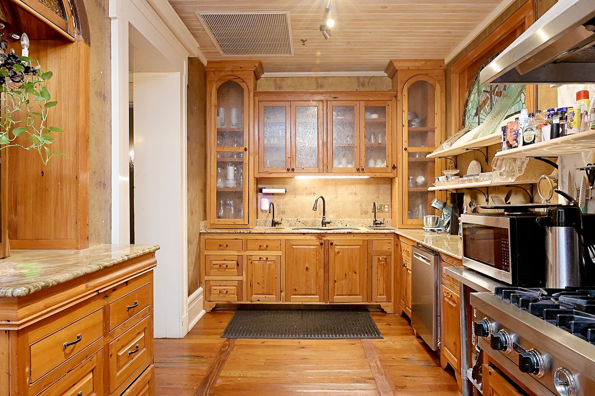 Wooden kitchen with cabinets, sink, and appliances.