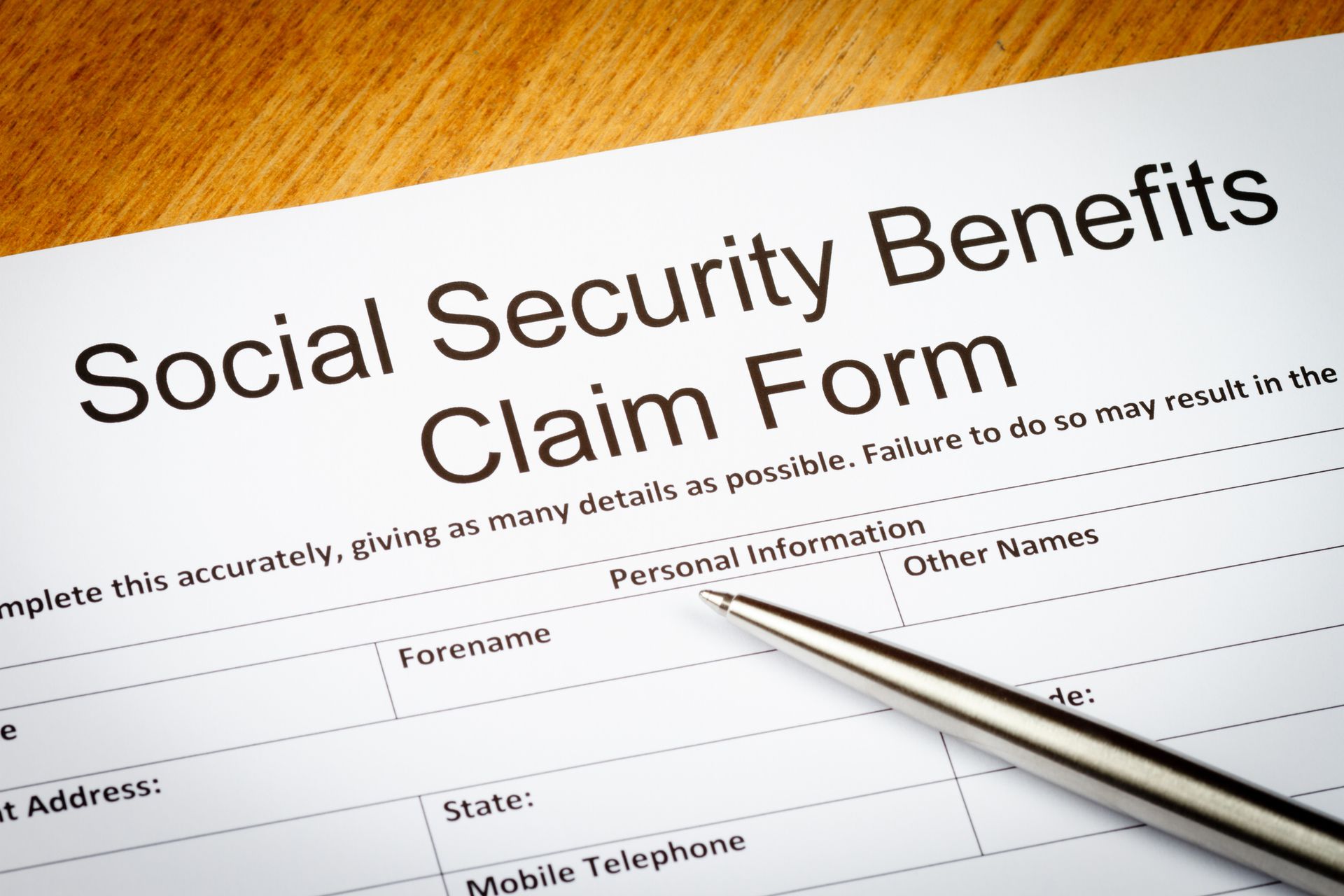 Social security benefits claim form with a pen on top.