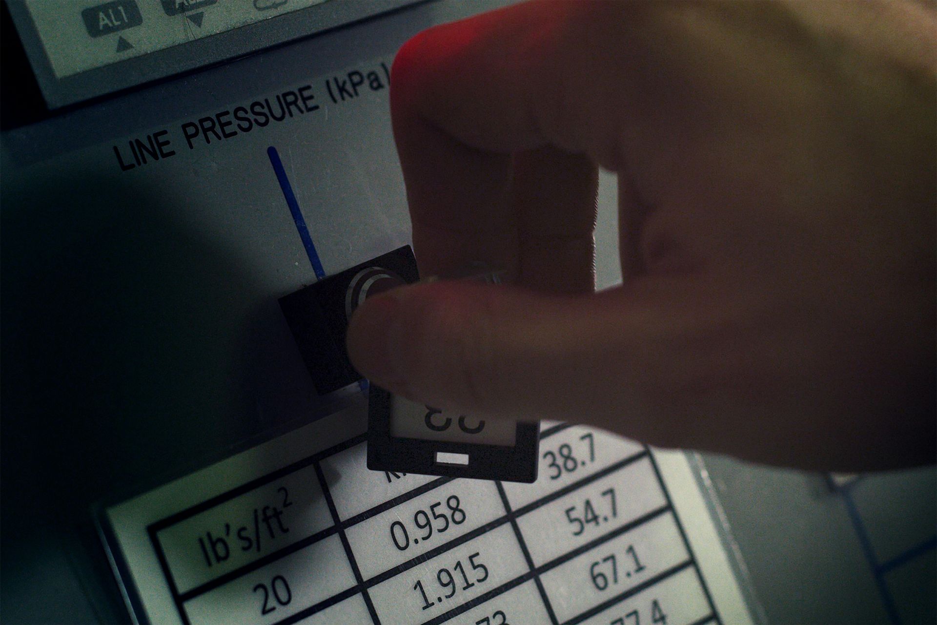 A hand turning a dial labeled 