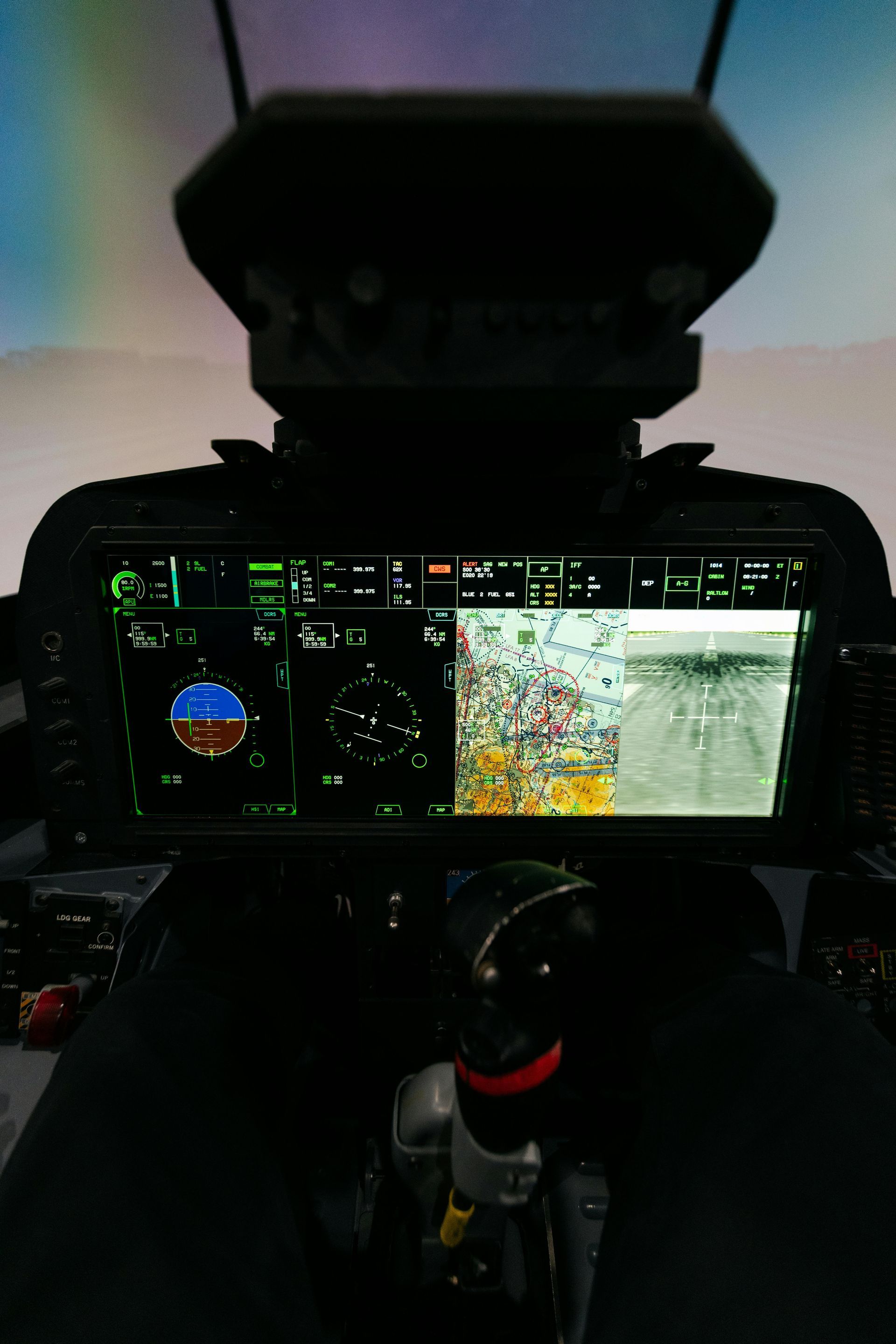 Cockpit view with two displays: one showing flight instruments, the other a view of a runway and surrounding area.