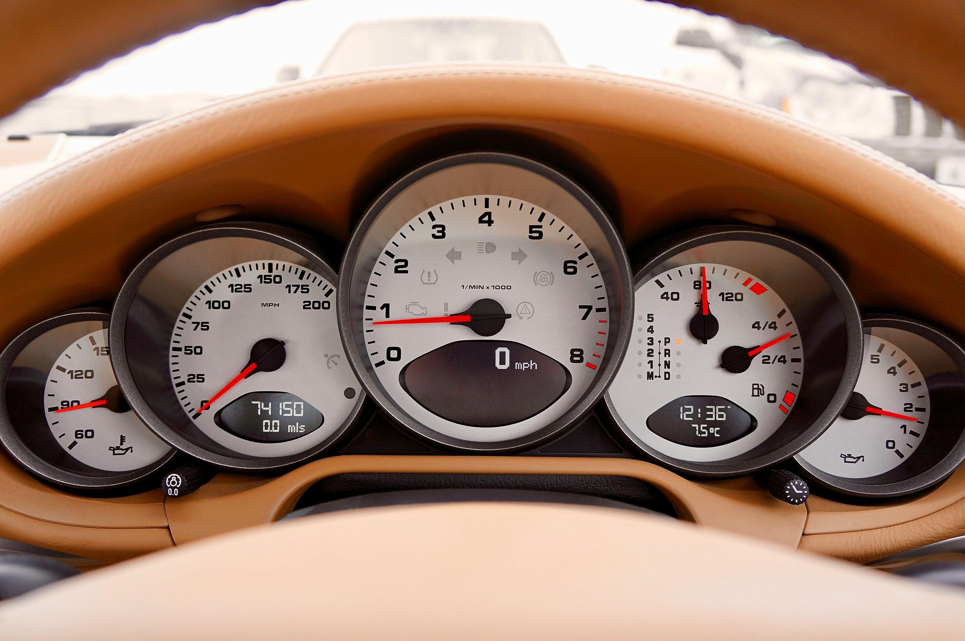 Car dashboard with gauges, tan leather. Speedometer reads 0, other gauges show fuel, oil, and engine status.