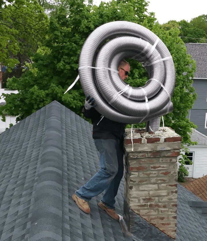 A man is carrying a large pipe on top of a roof