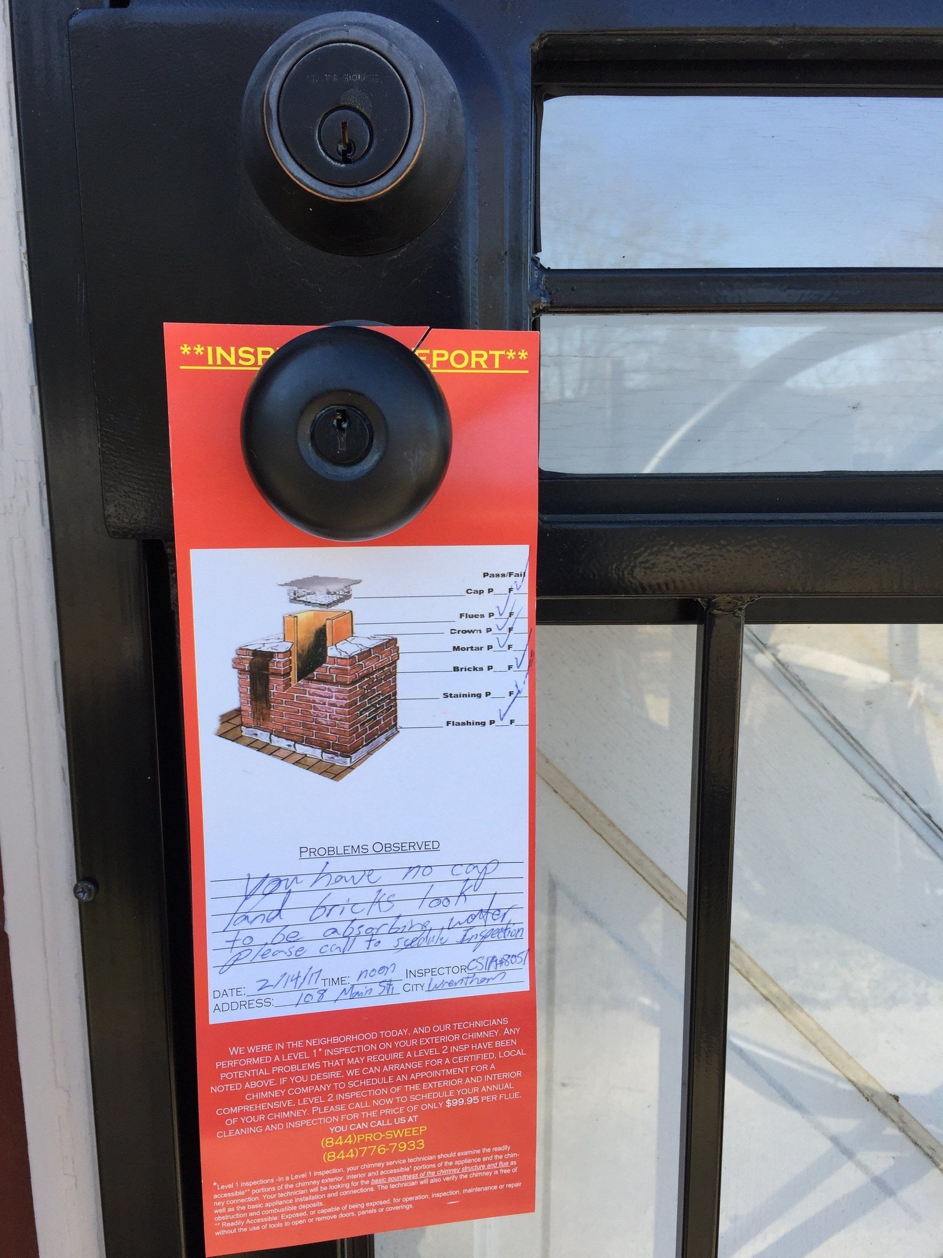 A door hanger with a picture of a brick building on it