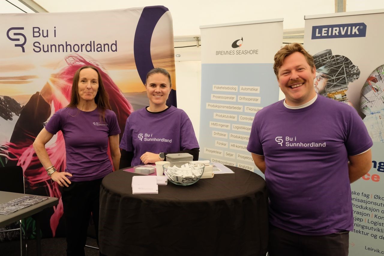 Foto av tre personar på stand iført t-skjorter med logo Bu i Sunnhordland