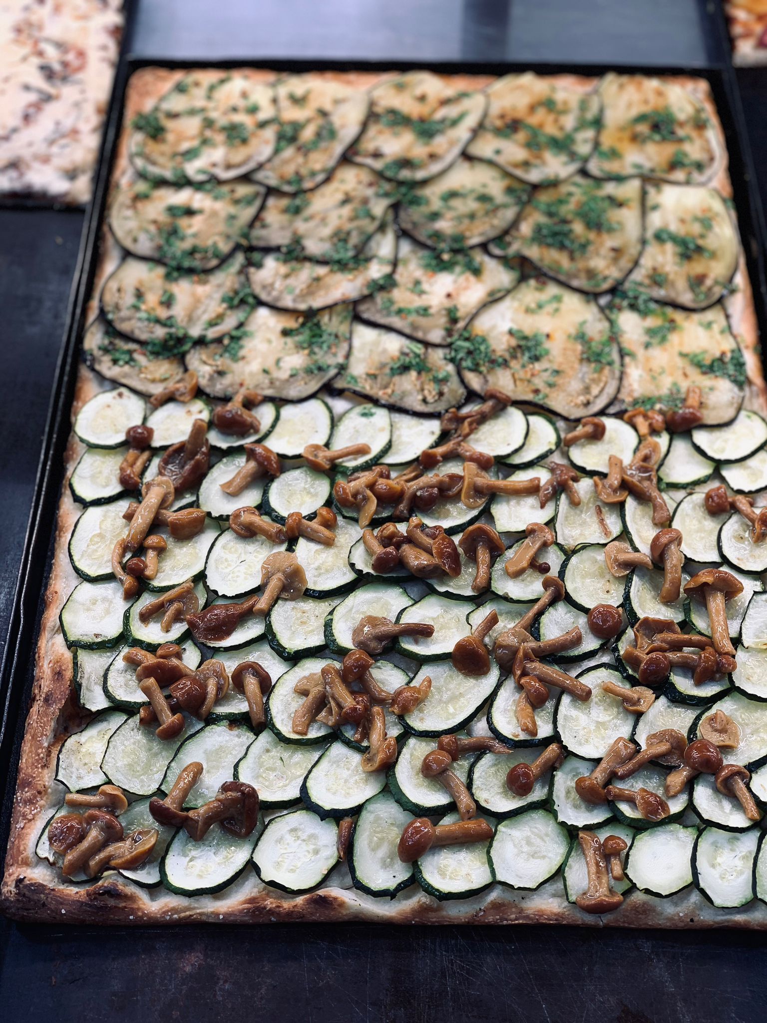 Una pizza con zucchine, funghi e melanzane.