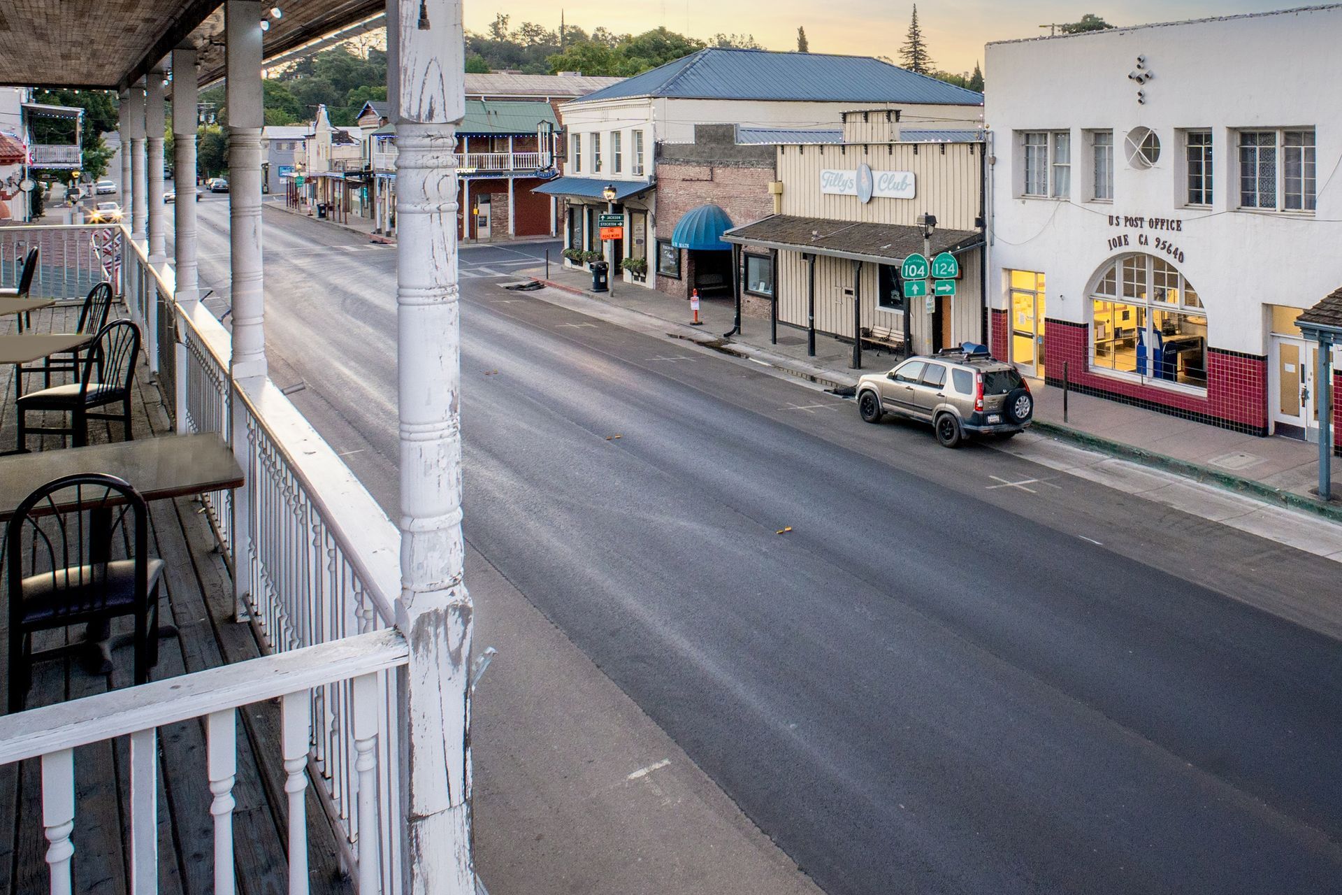 A car is driving down a street in a small town