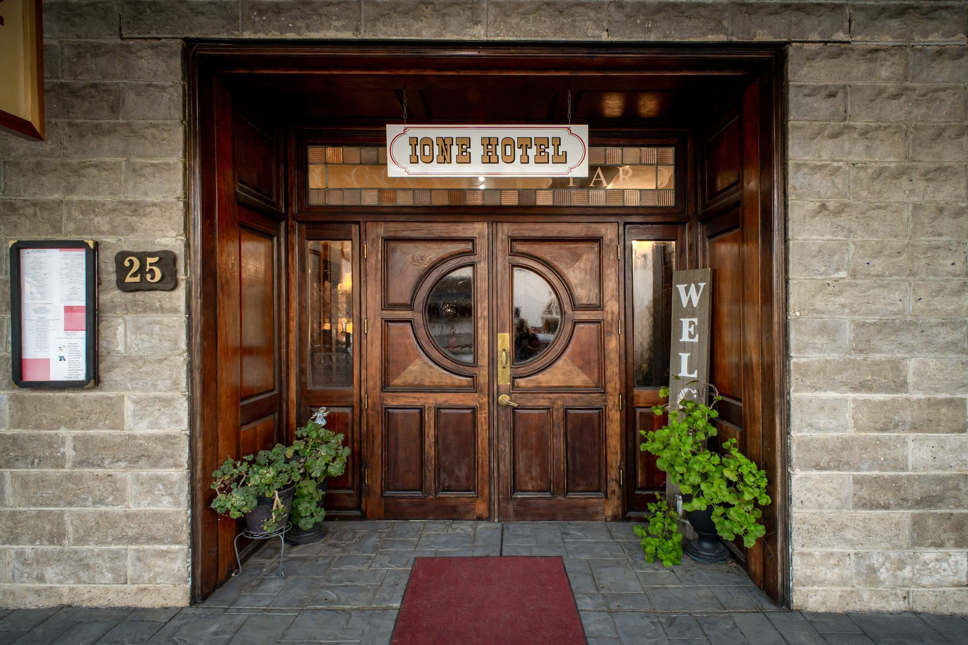 The front door of a hotel with a sign that says welcome.