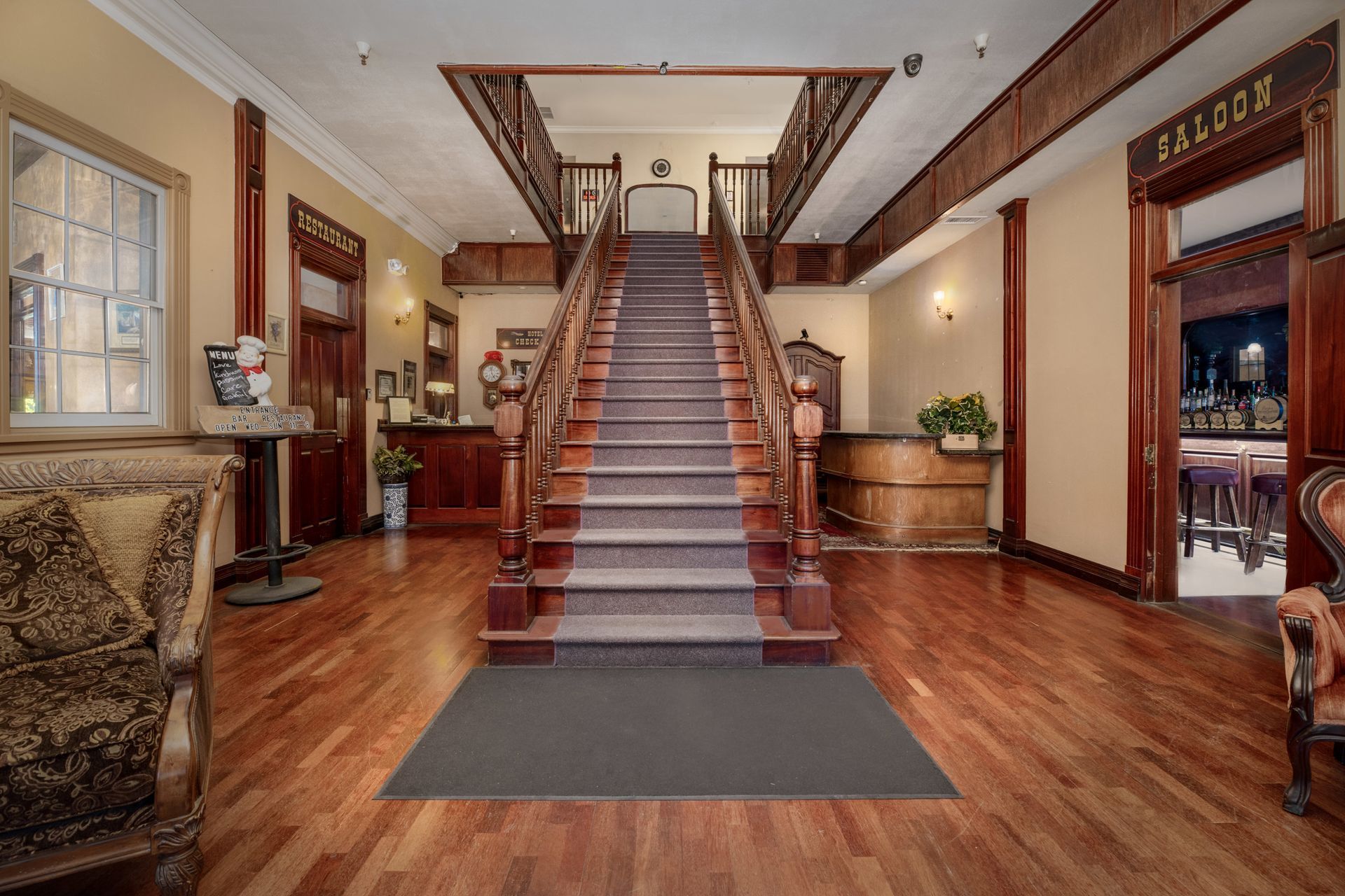 A hotel lobby with stairs leading up to the second floor