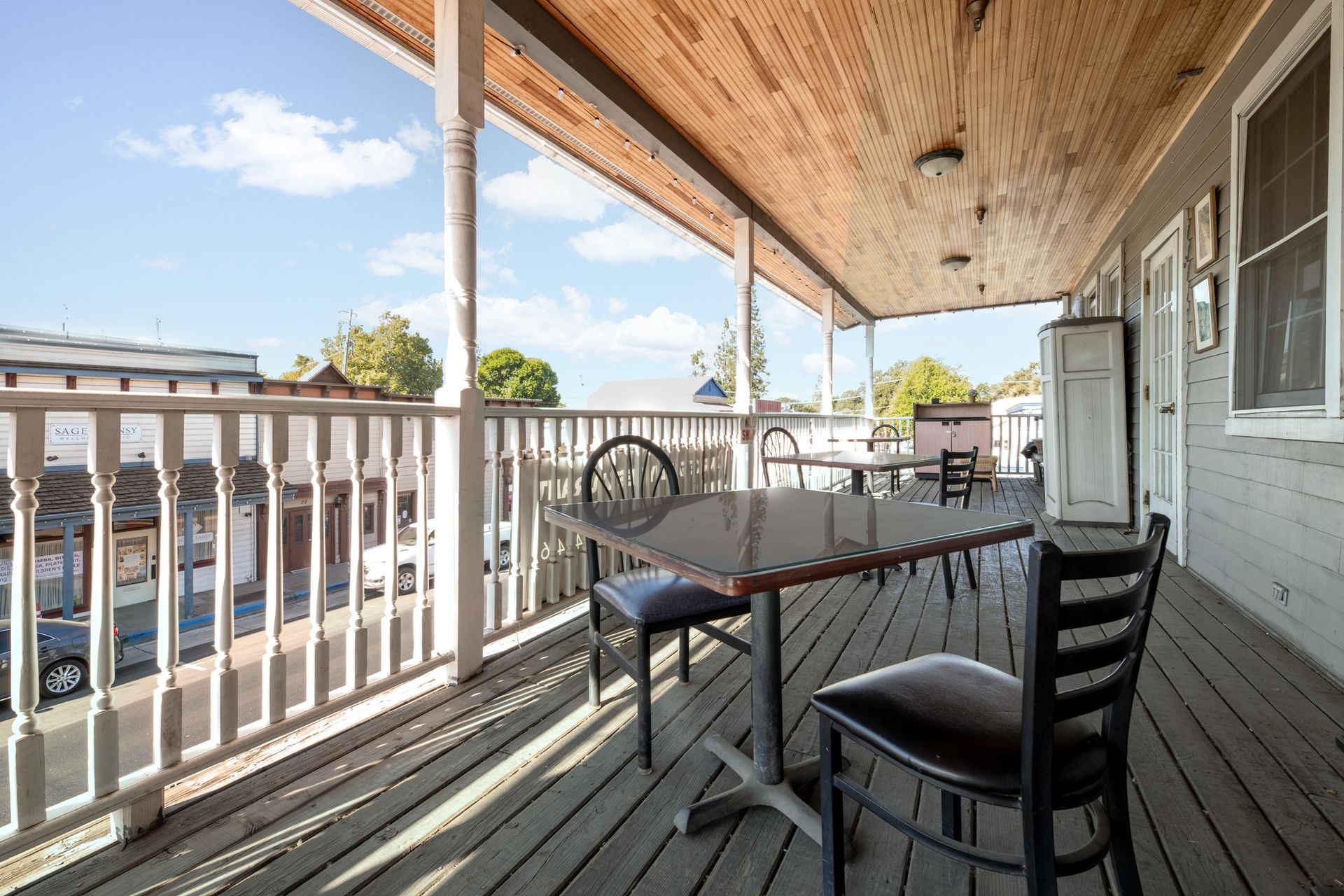 A porch with a table and chairs on it
