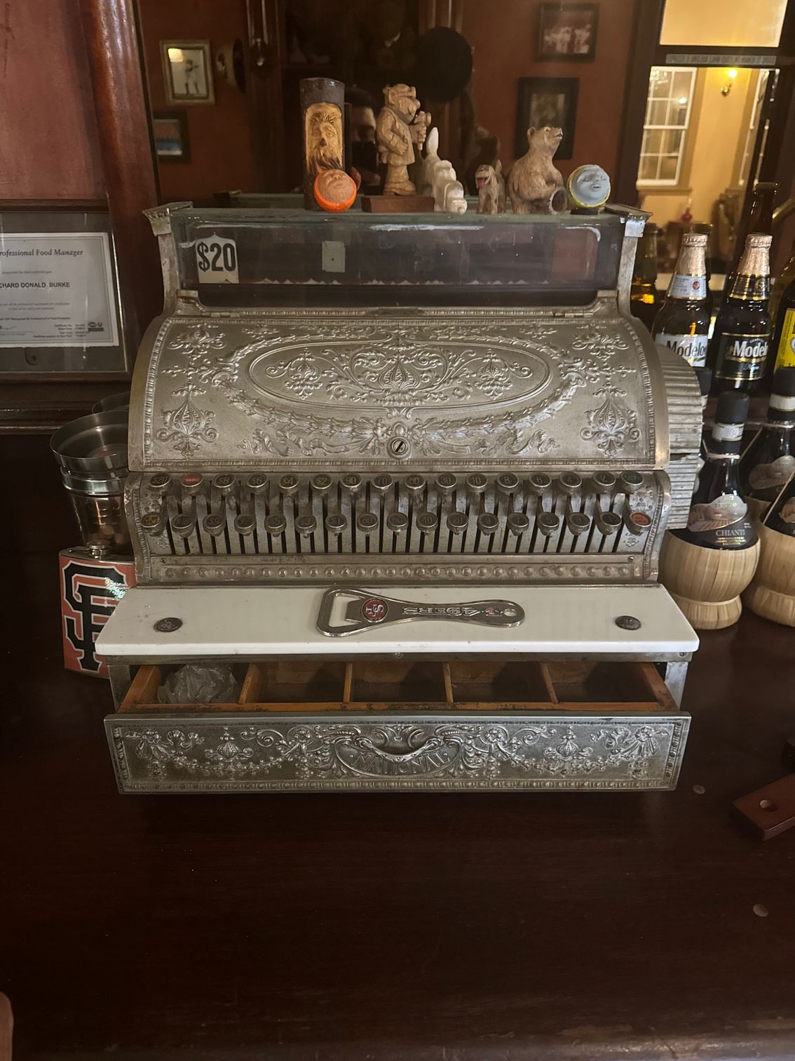 An old cash register is sitting on a wooden table.