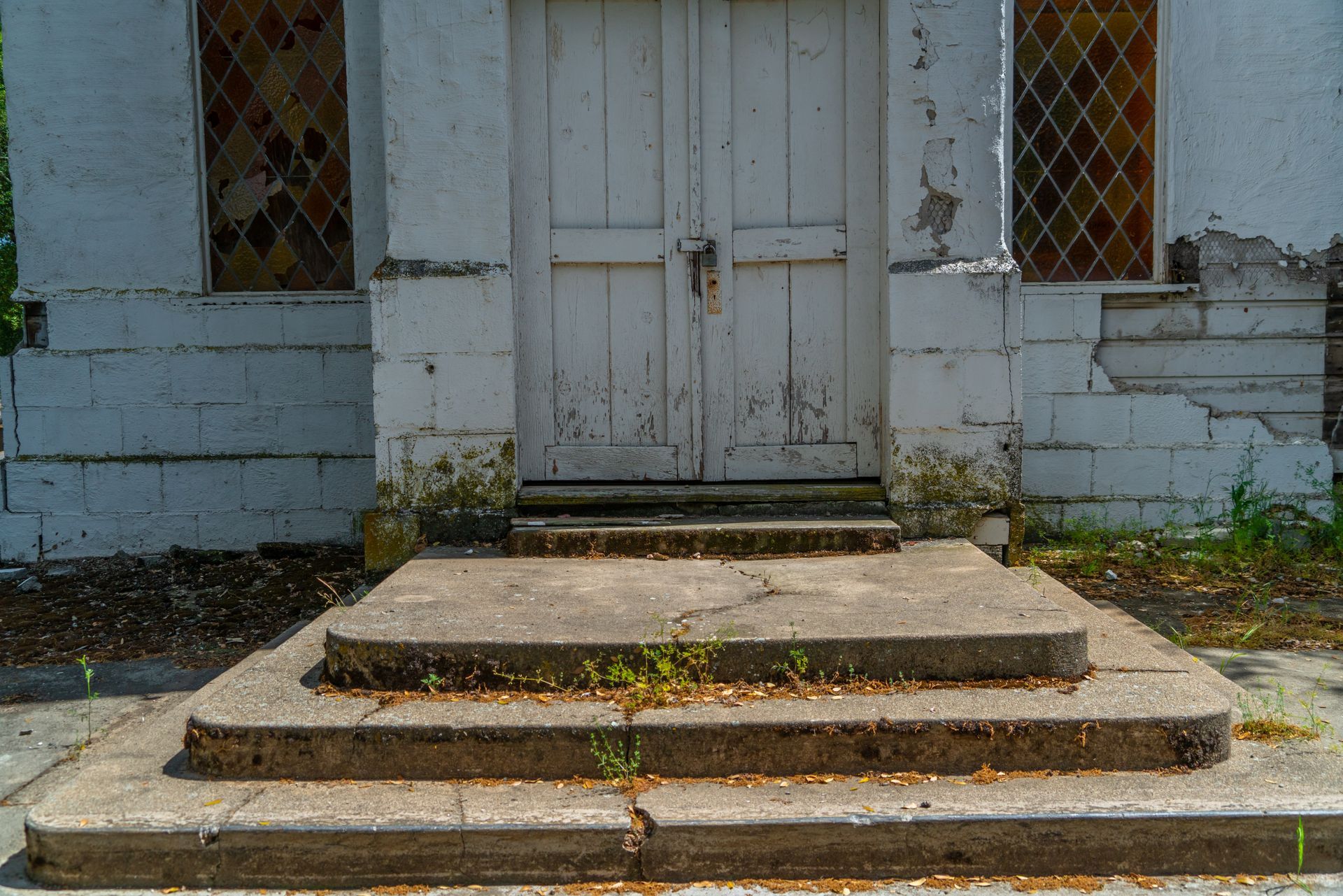 A set of concrete steps leading up to a white door