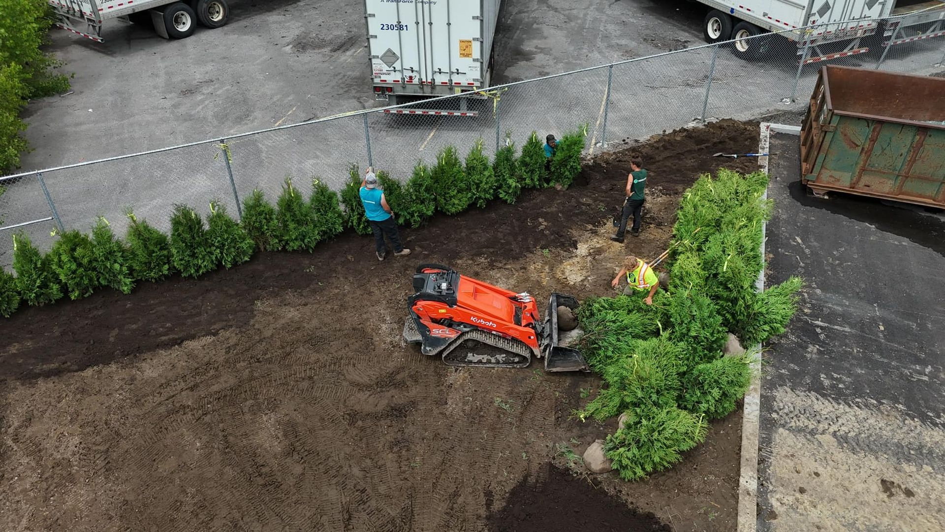 Une vue aérienne d'un chantier de construction avec un tracteur et des ouvriers.