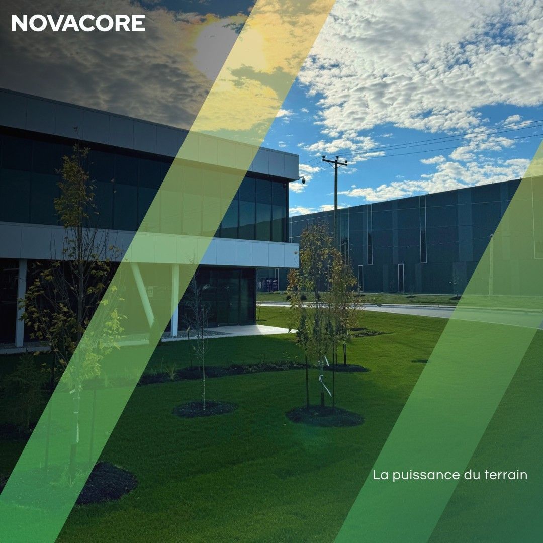 Un grand bâtiment avec beaucoup de fenêtres et d'arbres devant lui.