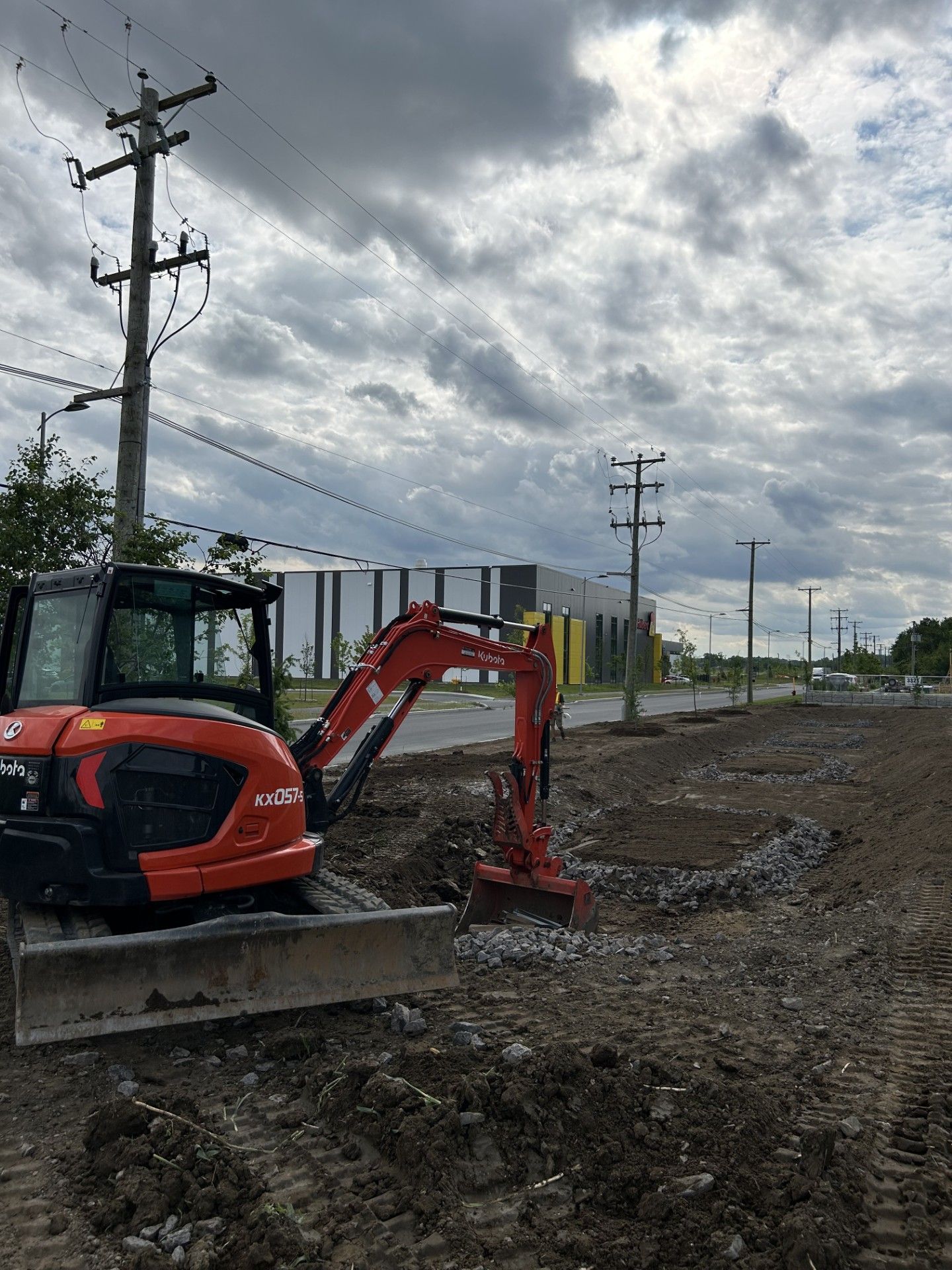 Une excavatrice rouge et noire est assise sur un champ de terre.
