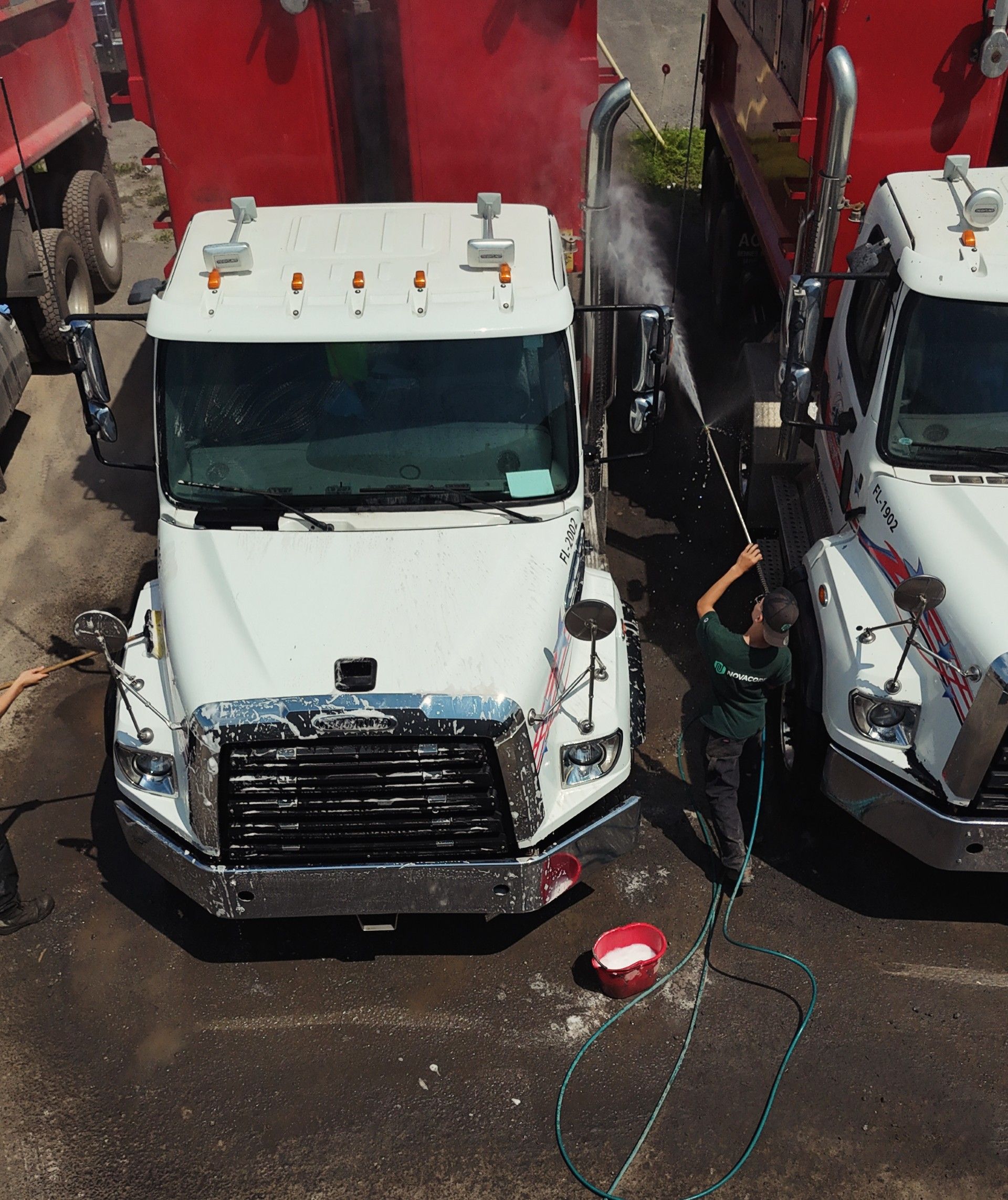 Deux camions blancs sont garés l'un à côté de l'autre sur un parking