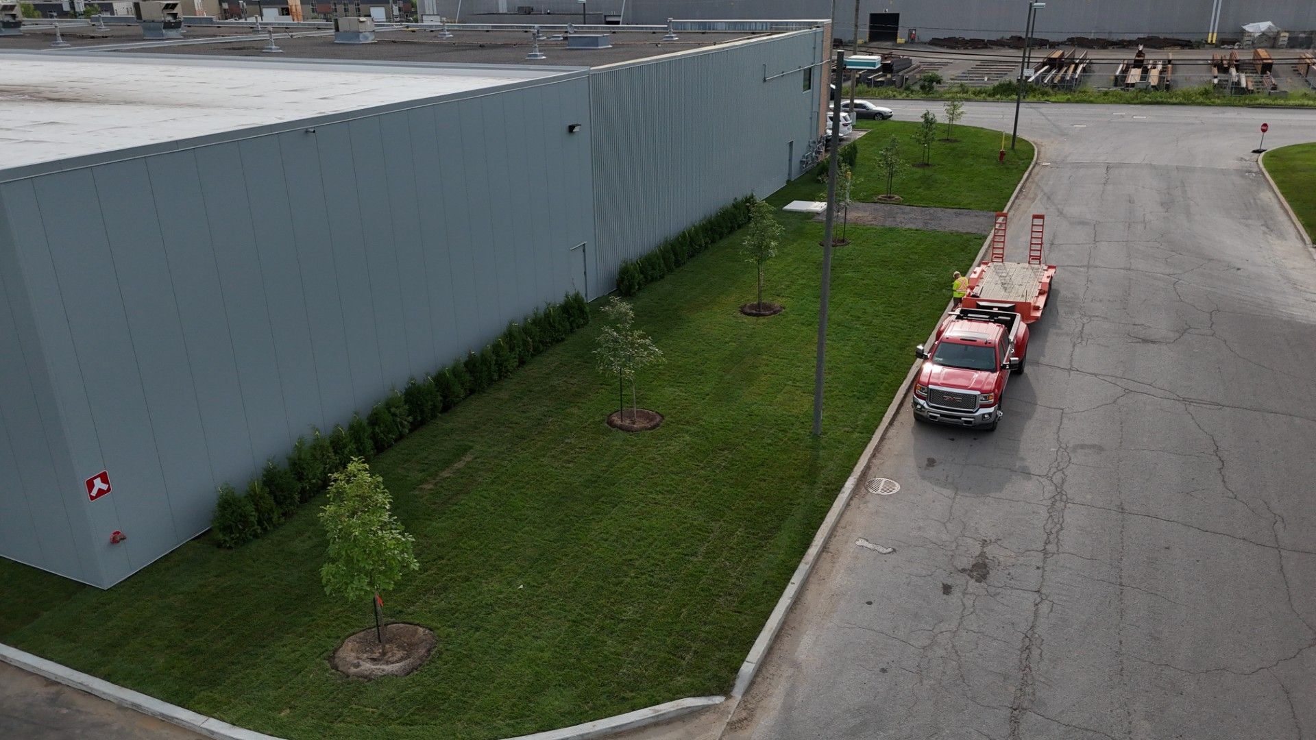 Un camion rouge est garé devant un grand bâtiment.