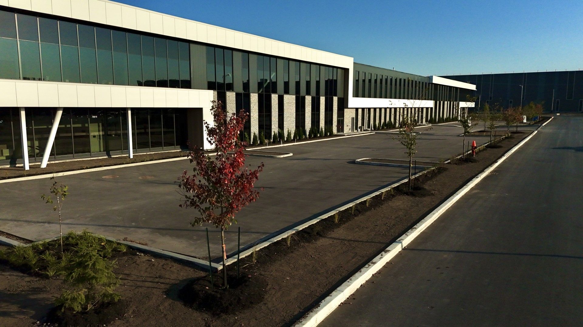 Un grand bâtiment avec beaucoup de fenêtres et d'arbres devant lui