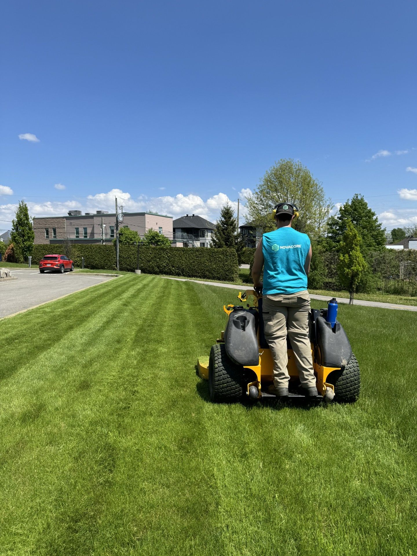Un homme conduit une tondeuse à gazon sur une pelouse verte luxuriante.