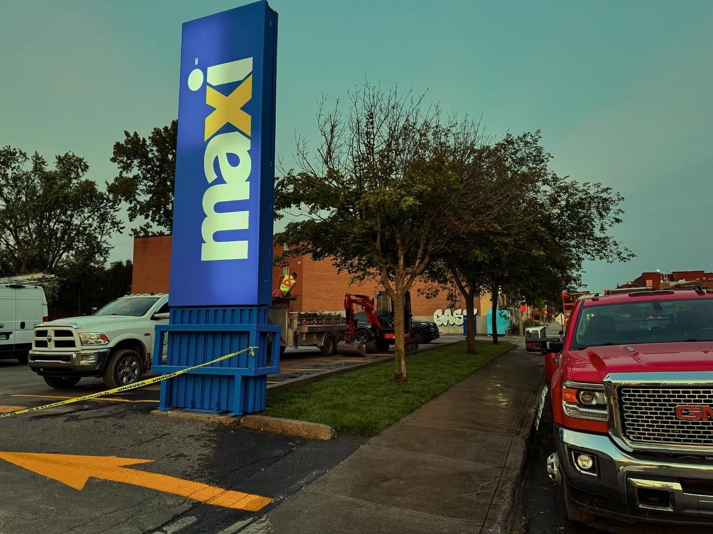 Un panneau bleu maxi est dans un parking
