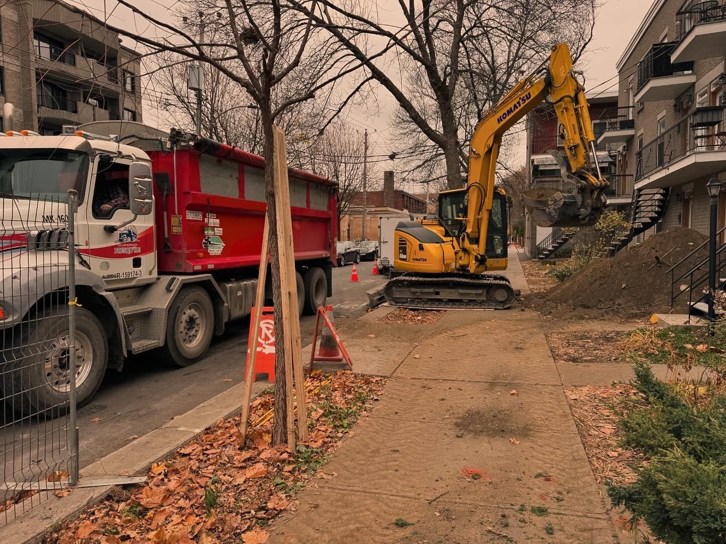 Un camion à benne basculante est garé sur le bord de la route à côté d'une excavatrice.