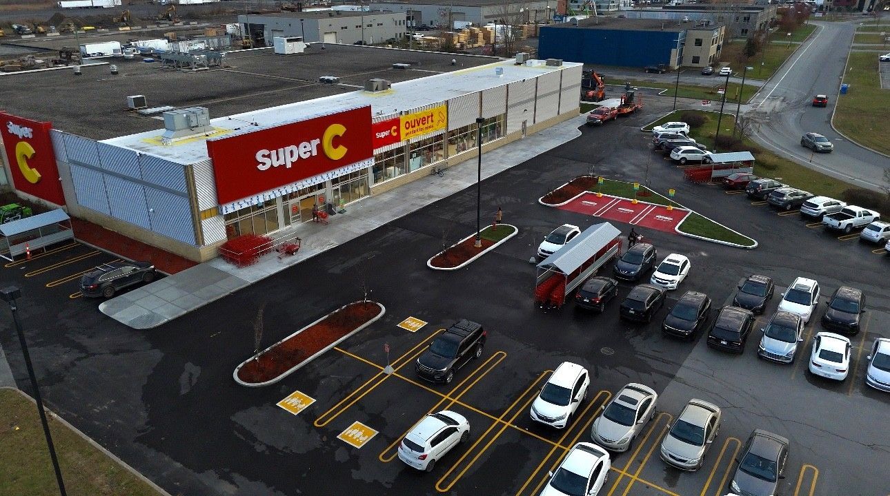 Une vue aérienne d'un magasin Super C avec des voitures garées devant.