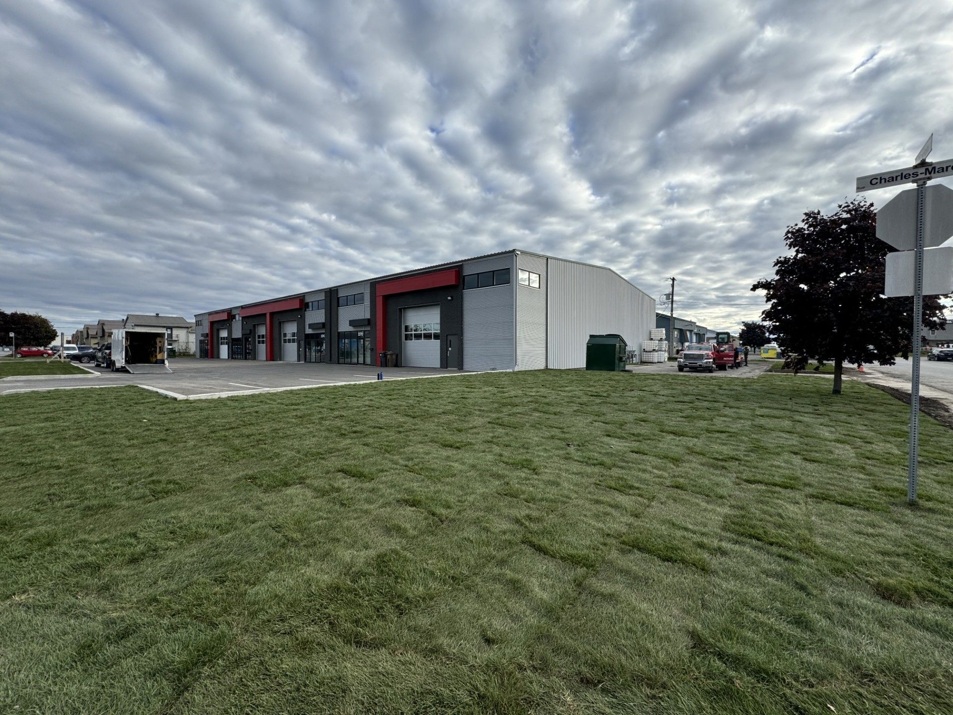 Un grand bâtiment avec beaucoup de fenêtres se trouve au sommet d'un champ verdoyant.