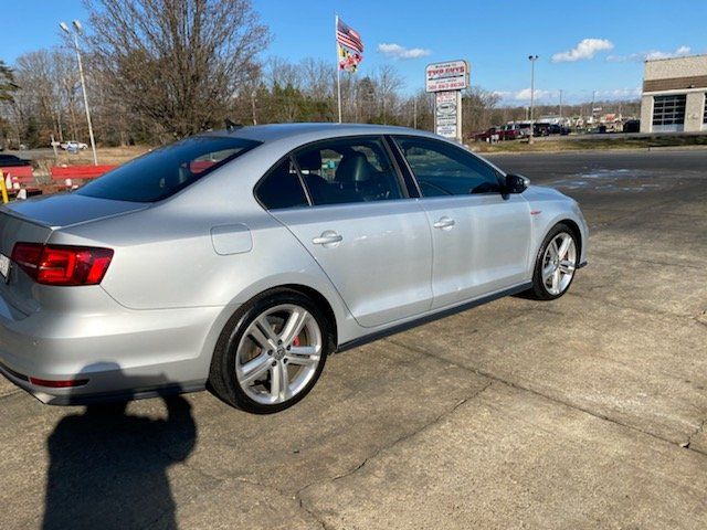 A silver volkswagen jetta is parked in a parking lot