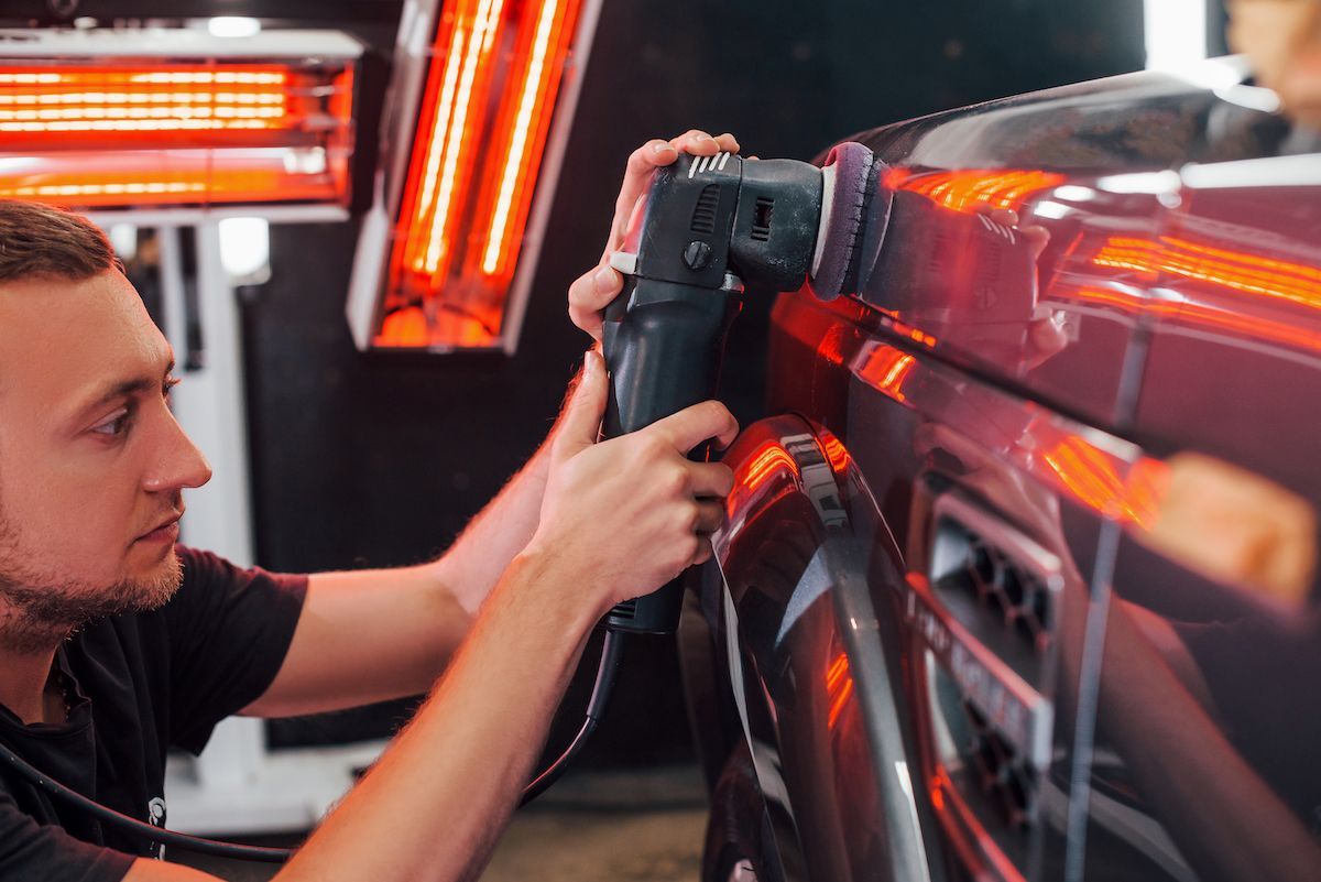 A man is polishing a car with a machine at a car wash in St. Mary's County MD.