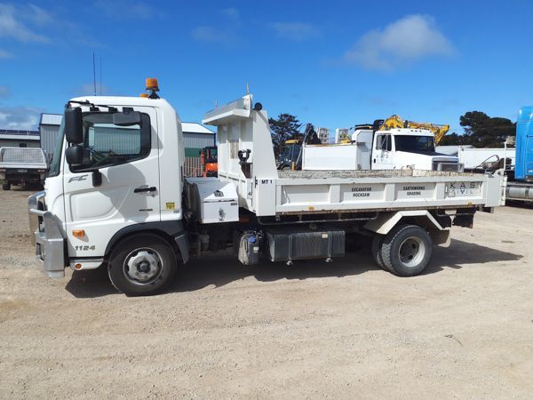 White dump truck on gravel, outdoors.
