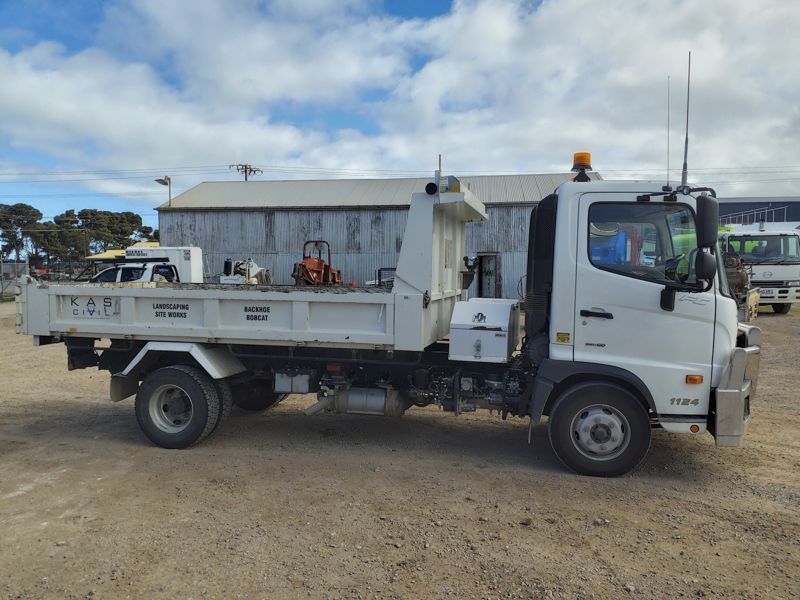 White dump truck parked outdoors on gravel.