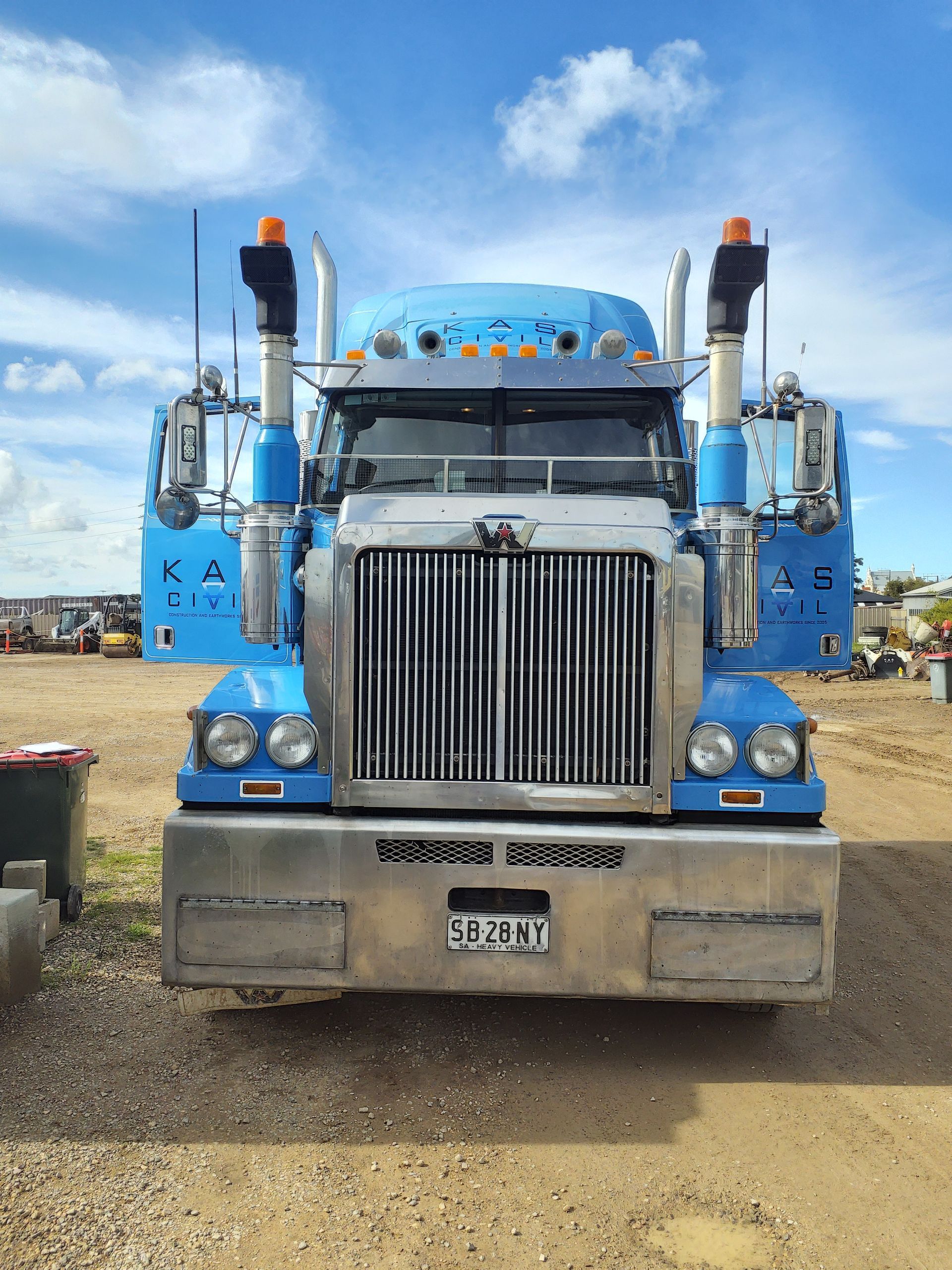 Blue semi-truck with chrome grill and bumpers. 