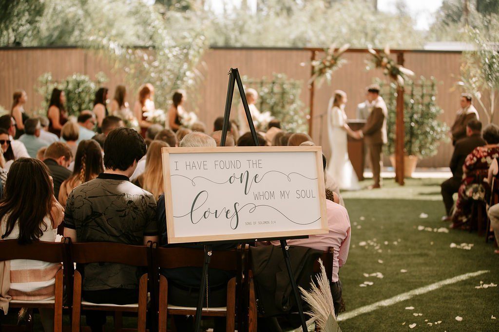 A group of people are sitting in chairs watching a wedding ceremony.