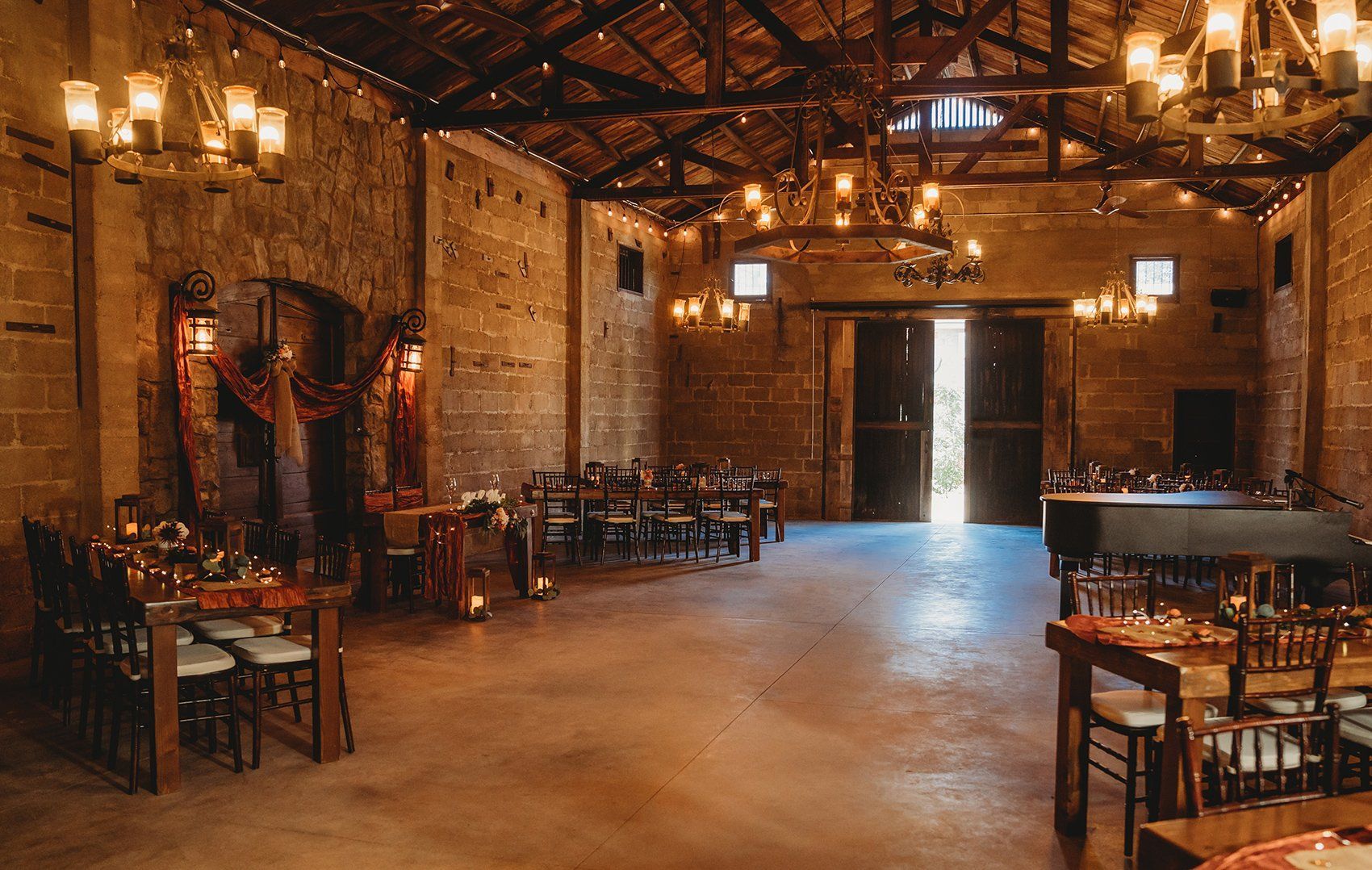 A large room with tables and chairs set up for a wedding reception.